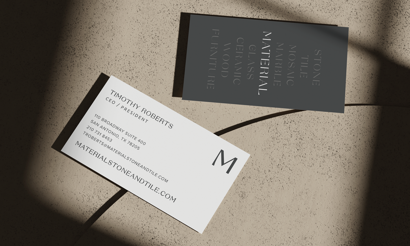 Business card for a CEO/President, with contact details including address in San Antonio, Texas, and an informational card for a material stone and tile business. The business cards are placed on a textured surface with shadows.