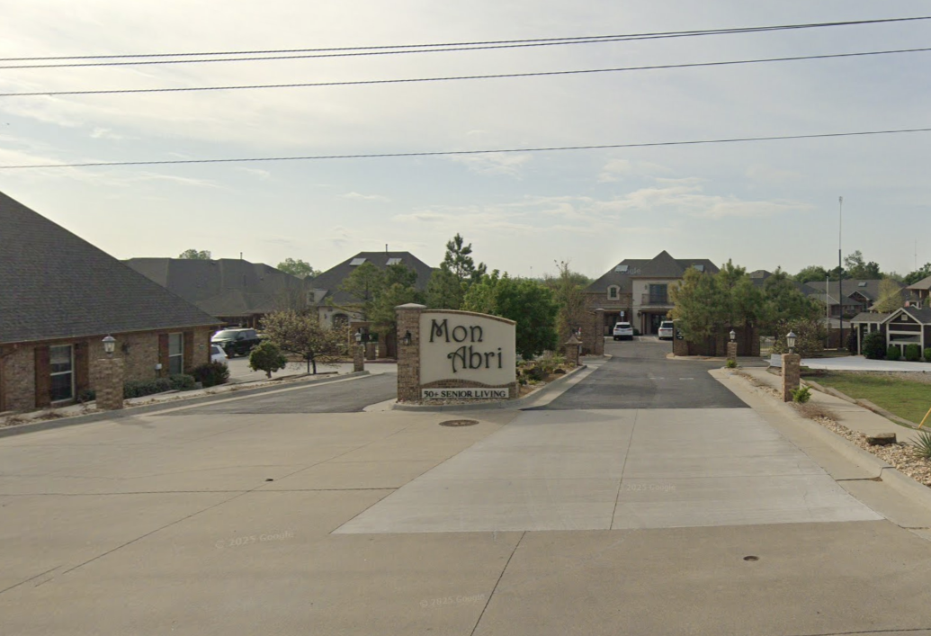 Entrance to Mon Abri, a senior living community for 50+ seniors, with a sign and a driveway leading into a residential area.