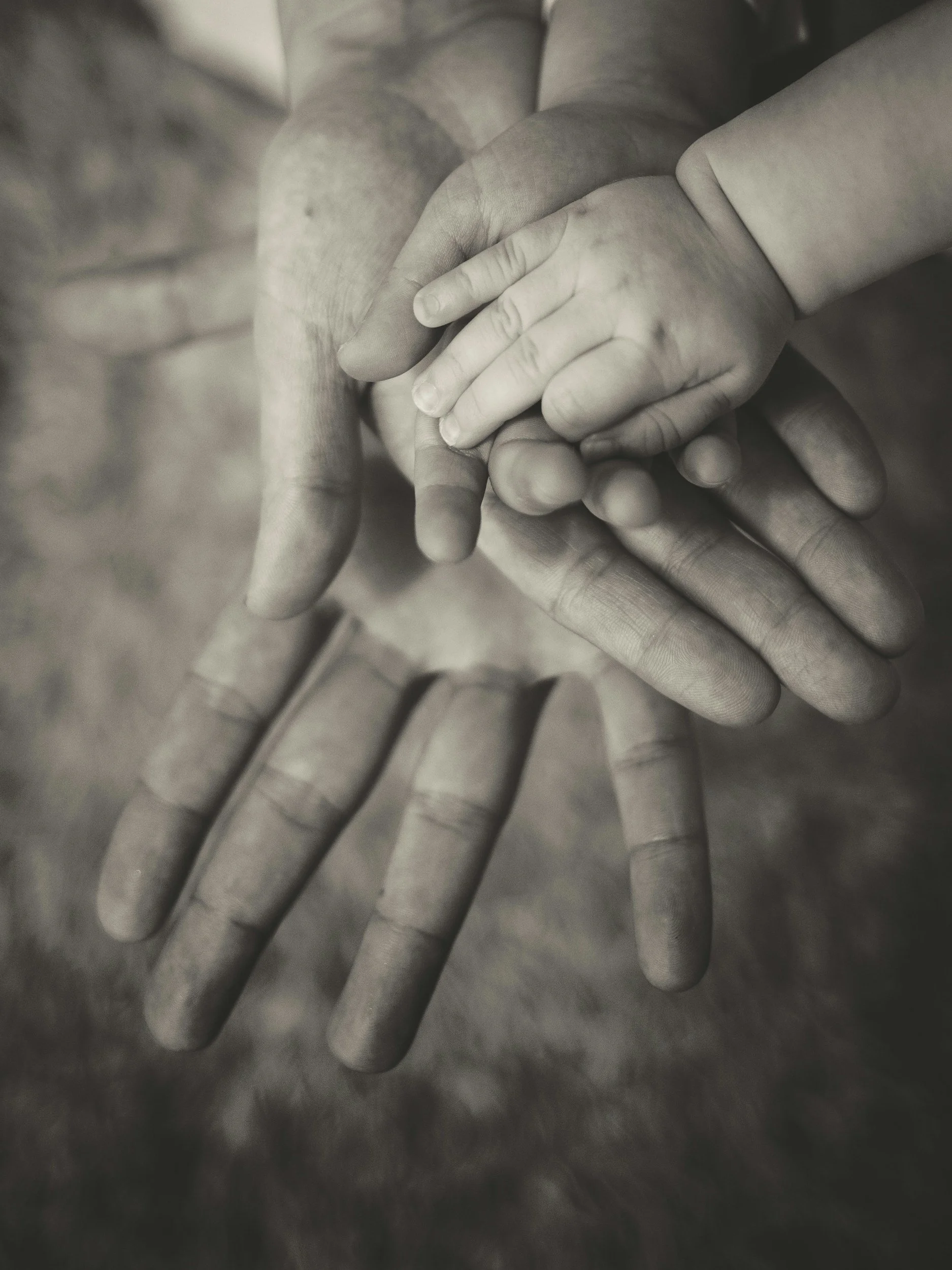 Close-up of multiple hands stacked together in a sign of unity.