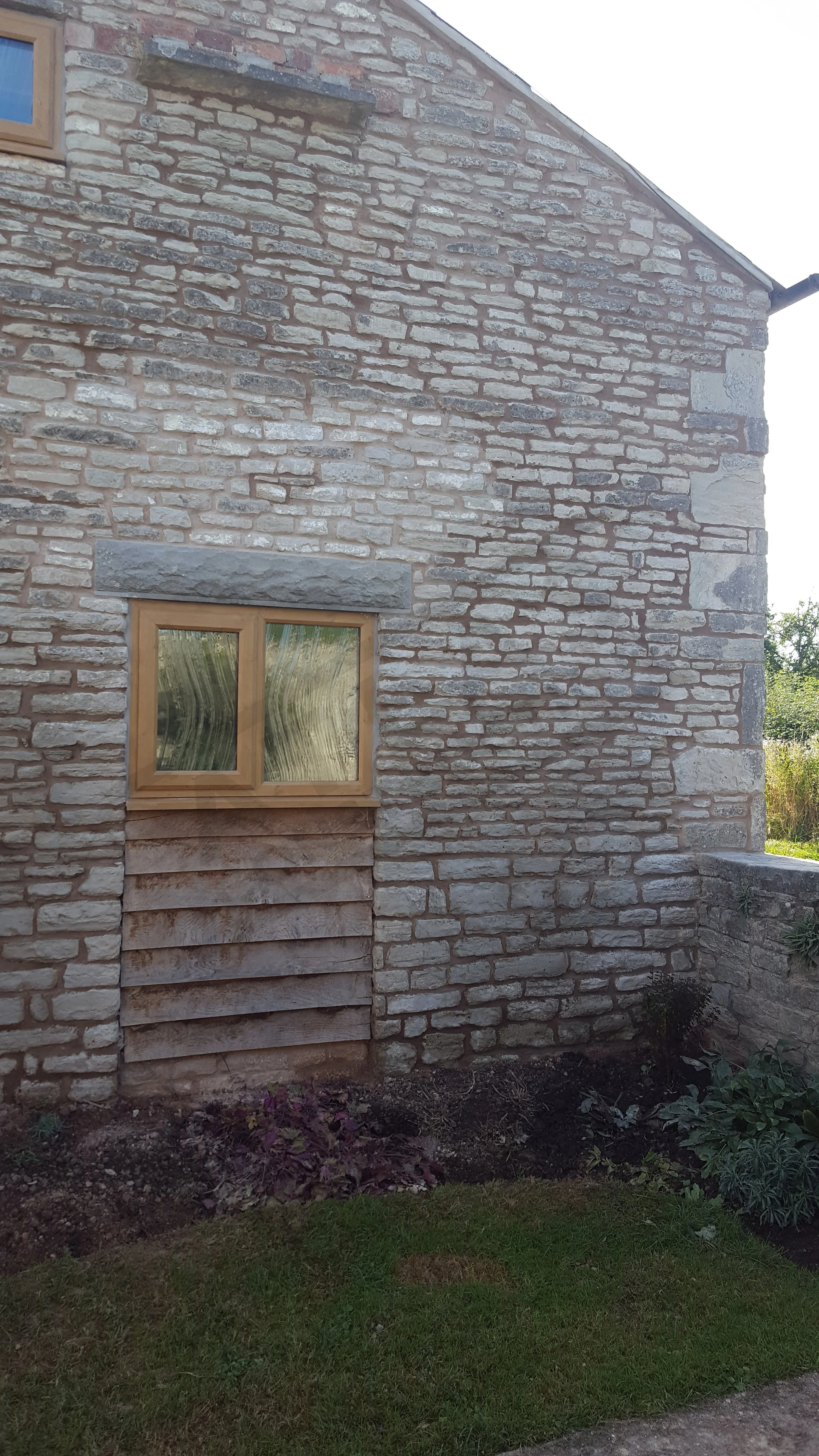 Rebuilt and repointed stonework around window on barn conversion