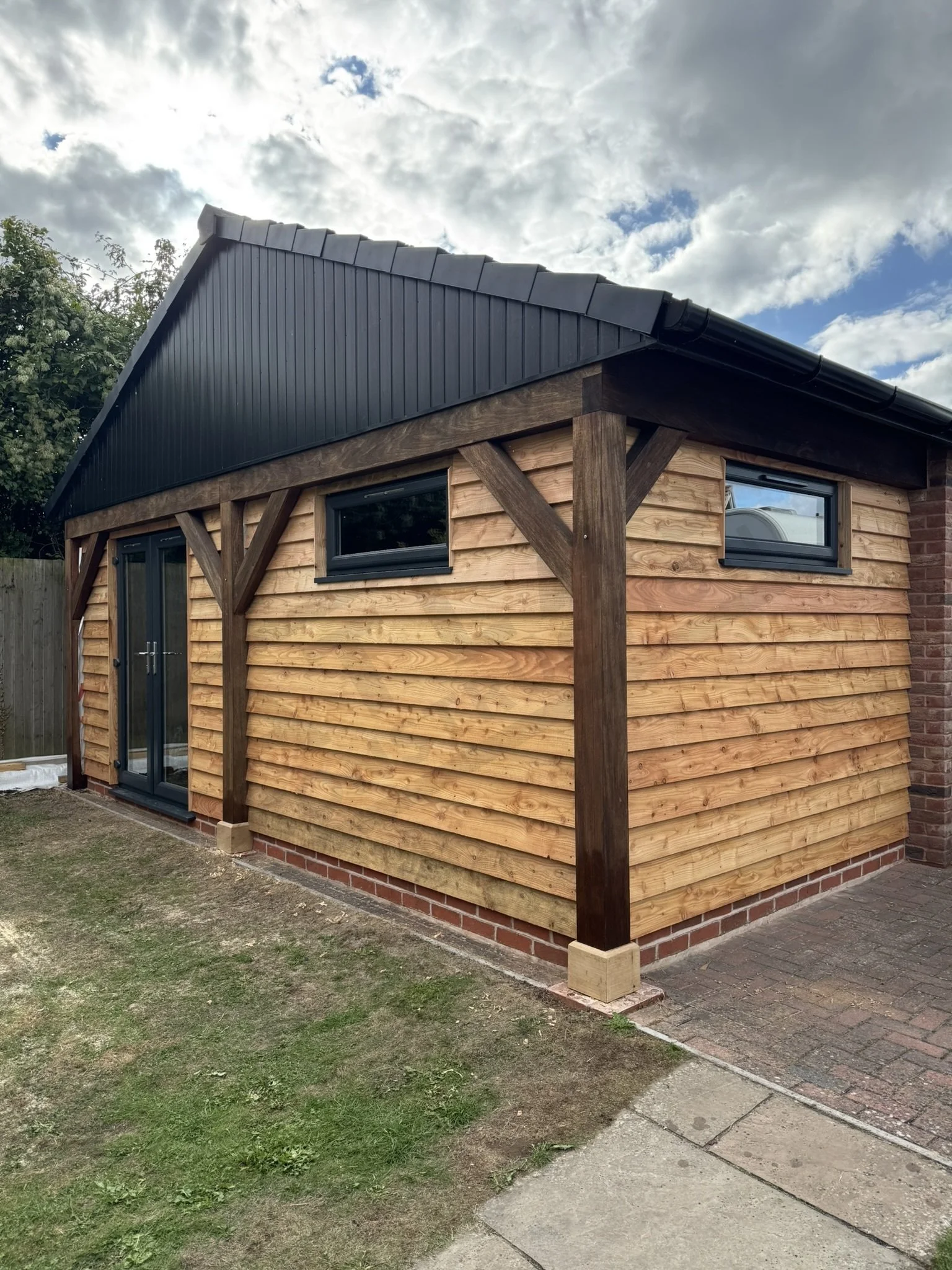Car port modified with cladding, windows and door to become extra indoor space.