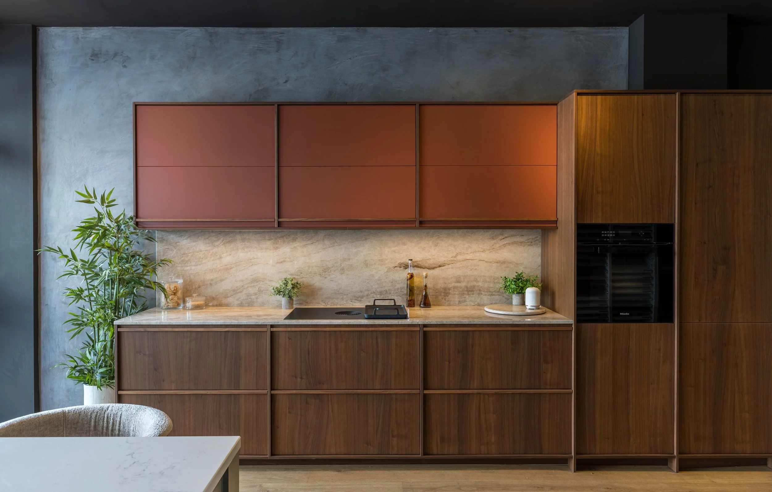 Contemporary kitchen interior photography with dark wood cabinetry and marble backsplash.