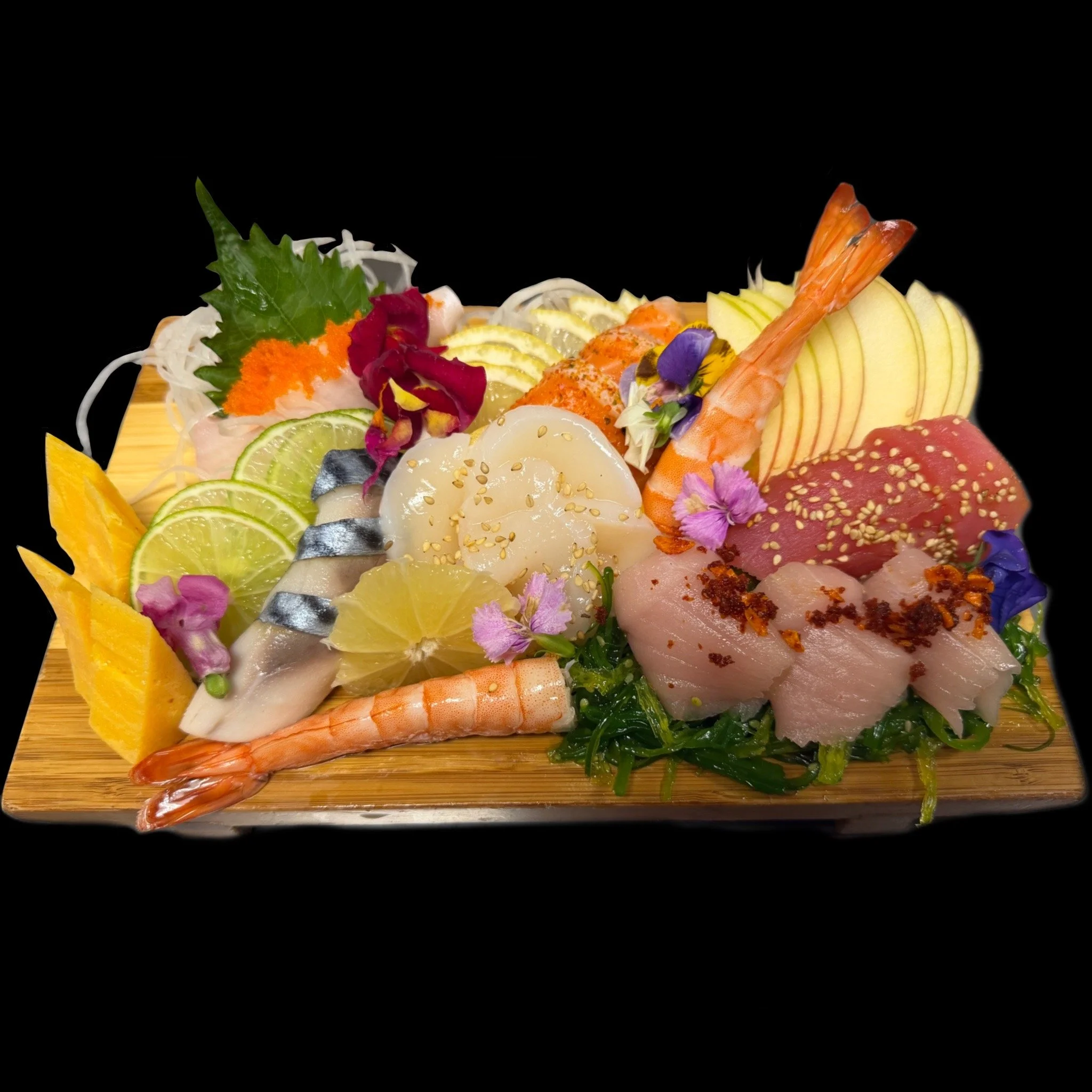 A sushi platter with various types of raw fish, shrimp, lemon slices, cucumber, decorative flowers, and garnishes on a wooden serving board.