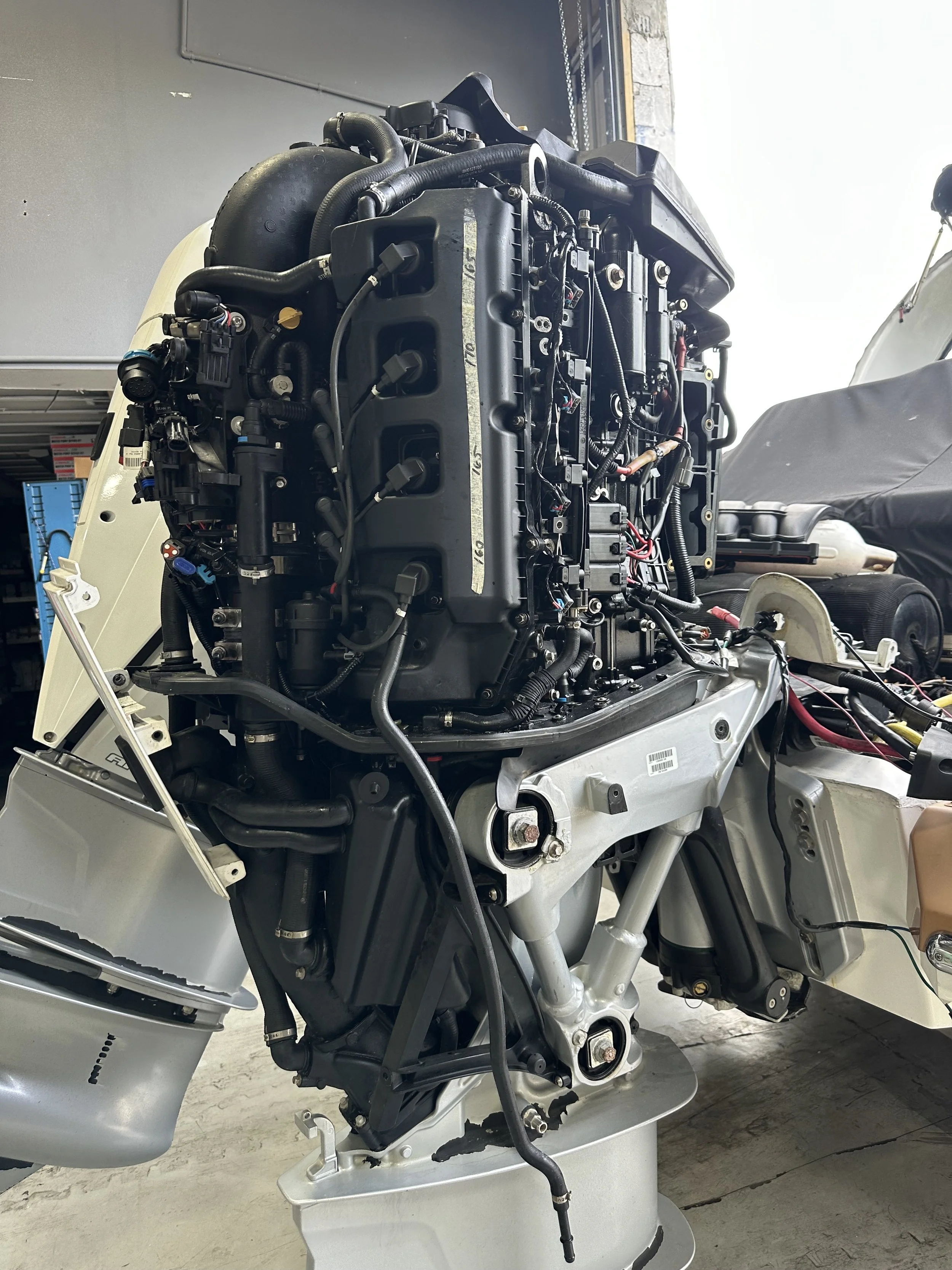 Outboard engine removed from a boat, displayed on a stand in a workshop