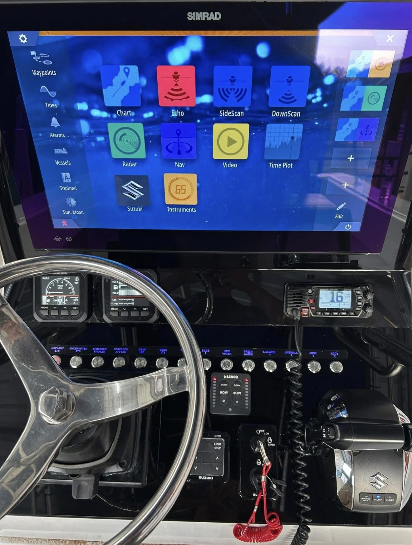 Digital dashboard of a boat or marine vessel showing navigation and system controls, with a large touchscreen display, steering wheel, and various electronic devices and gauges.
