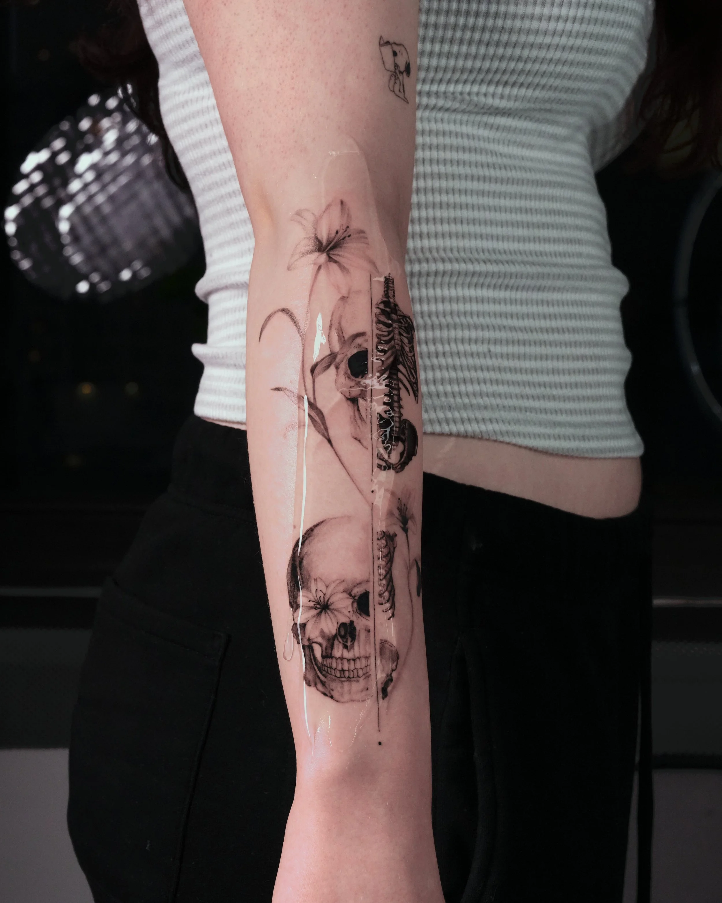 Micro-Realism skull and ribcage tattoo including soft shading floral details