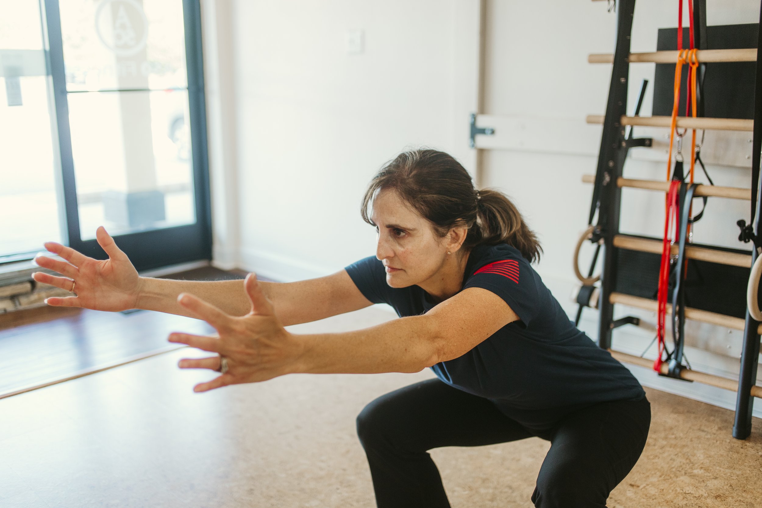 Woman over 50 performing a bodyweight squat to strengthen her legs