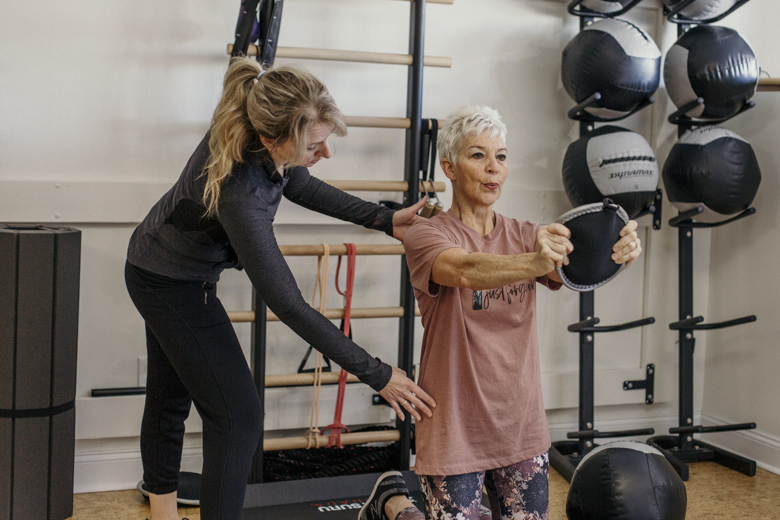 Personal trainer helping a client improve strength safely.