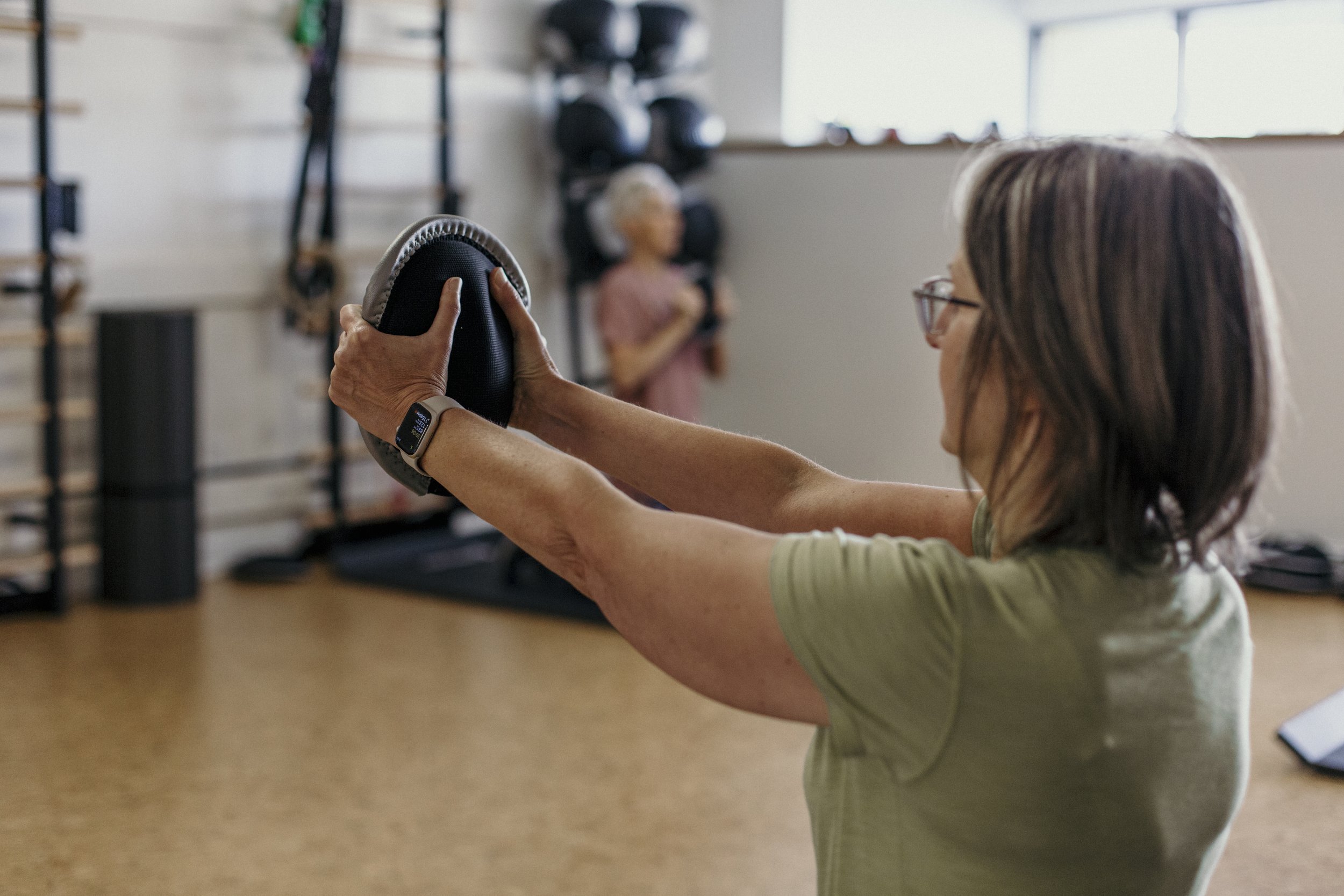 Woman performing an upper-body strength exercise during a personal training session.