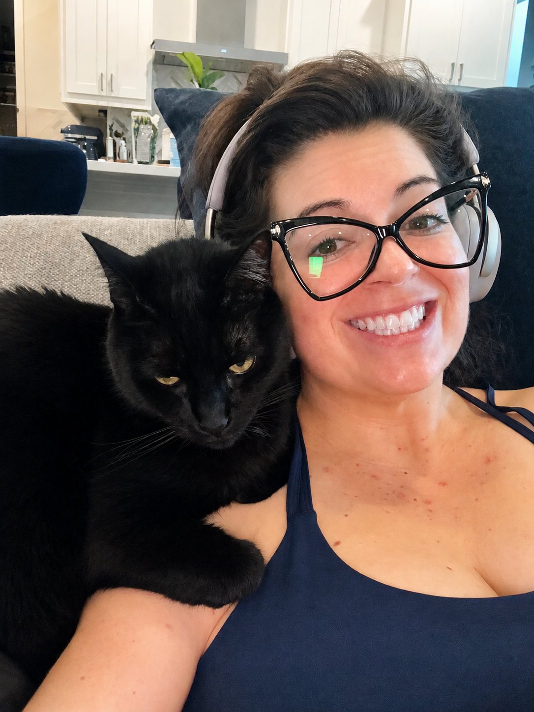 Angie wearing her third pair of glasses, summarizing her patient guide on how to navigate liver-related vision changes with a hepatologist
