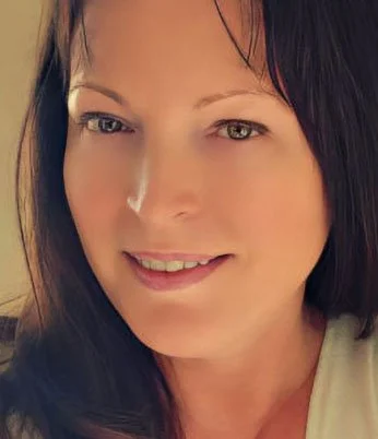 A woman with dark hair and light skin smiling at the camera.