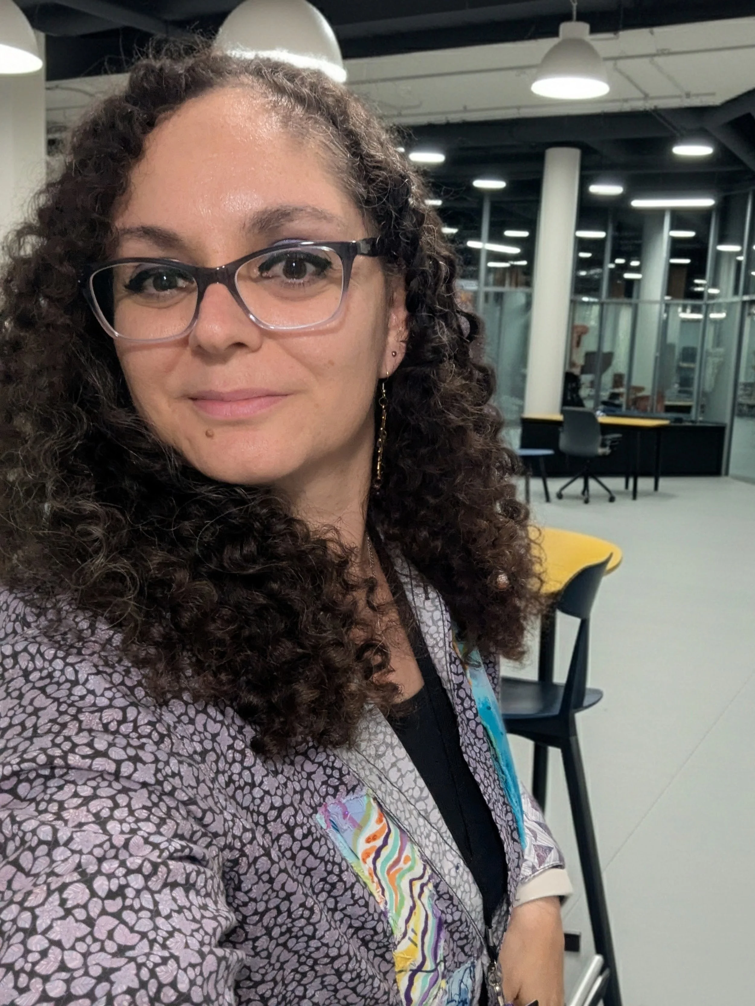 Image of Layal Rabat wearing glasses and a colorful patterned shirt