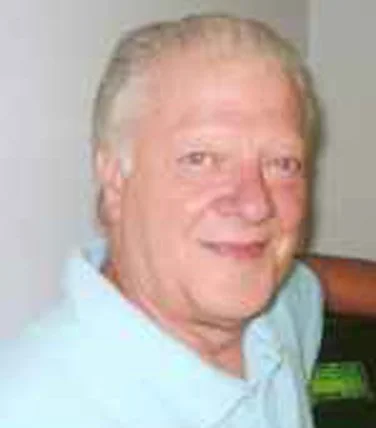 A middle-aged man with light-colored hair and a friendly smile, wearing a light blue polo shirt.