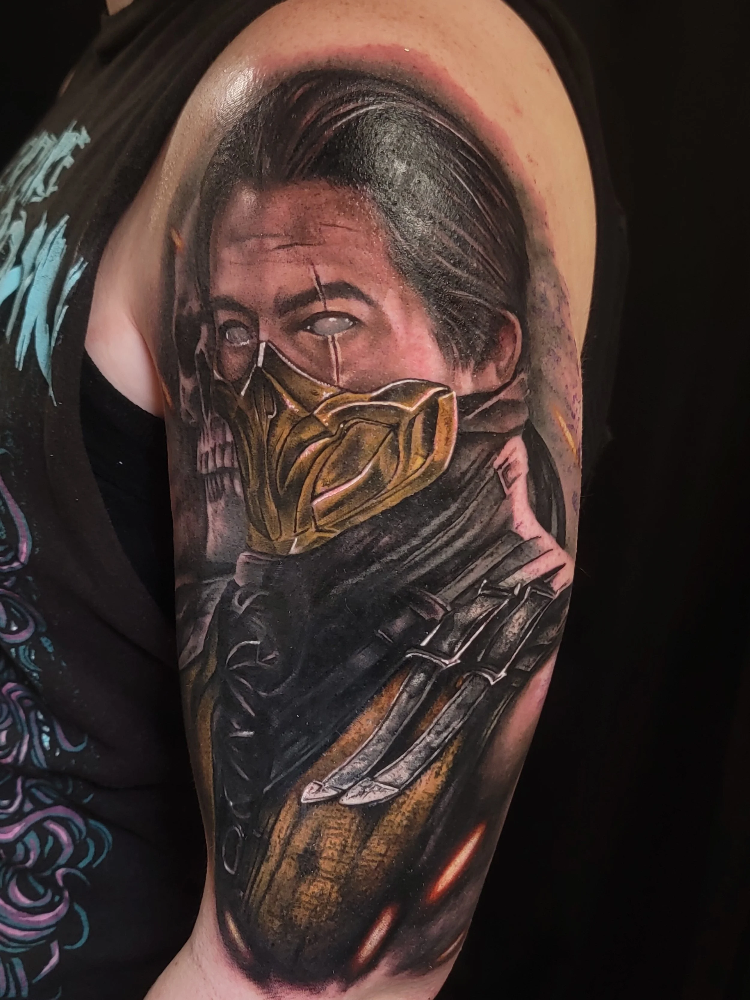 Close-up of a tattoo on a person's arm depicting a video game character wearing a mask, with dark swirling background.