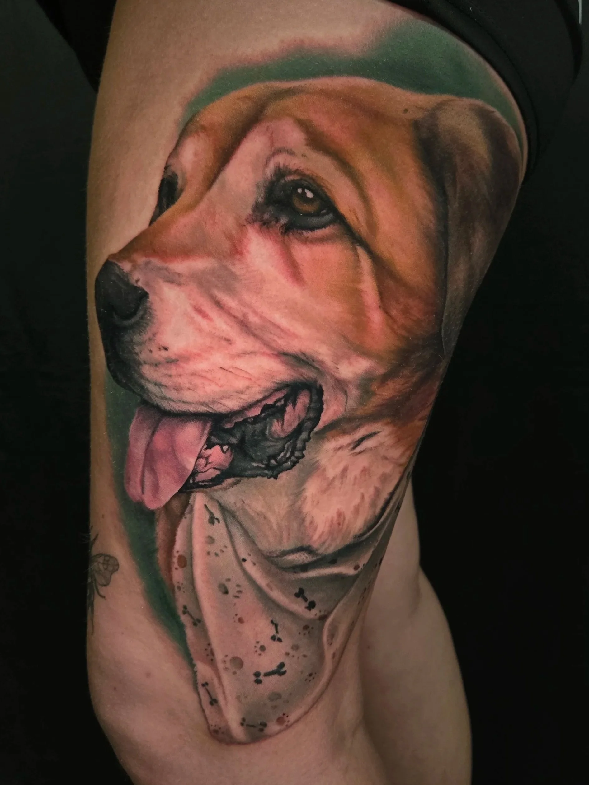Tattoo of a dog's face on a person's thigh, with realistic shading and details.