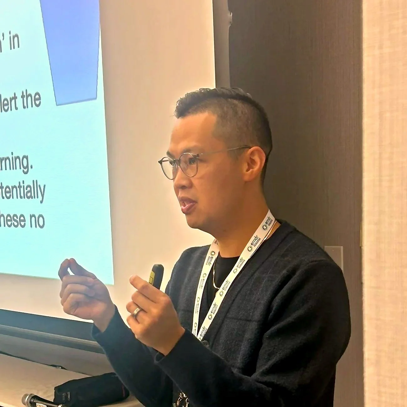 Kyle Poon, R.Psych, explaining a concept beside a slide while teaching EMDR