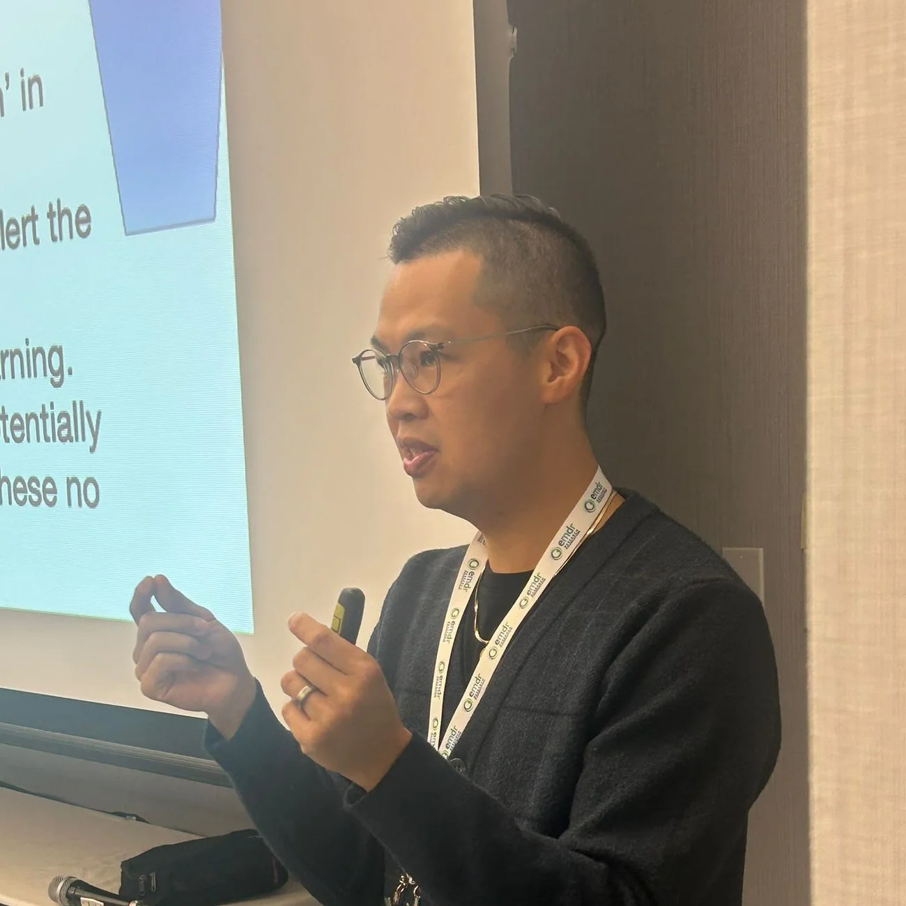Kyle Poon, R.Psych, explaining a concept beside a slide while teaching EMDR