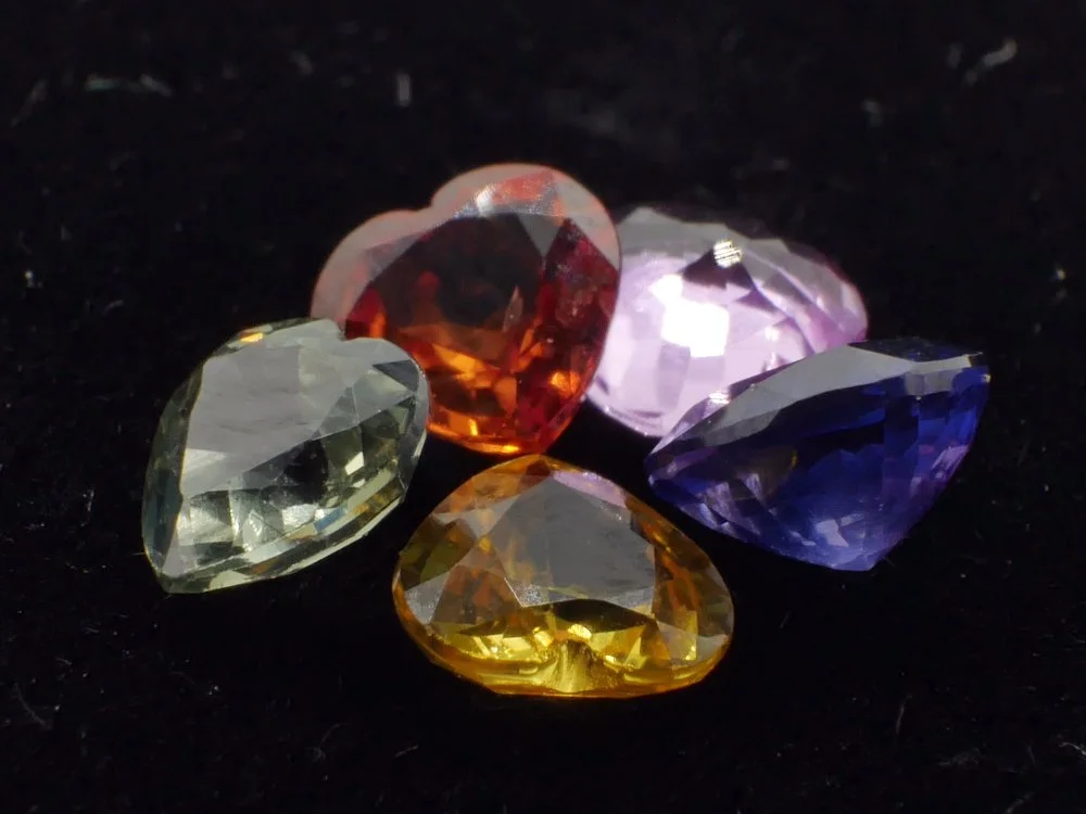 Five synthetic sapphires, black bg