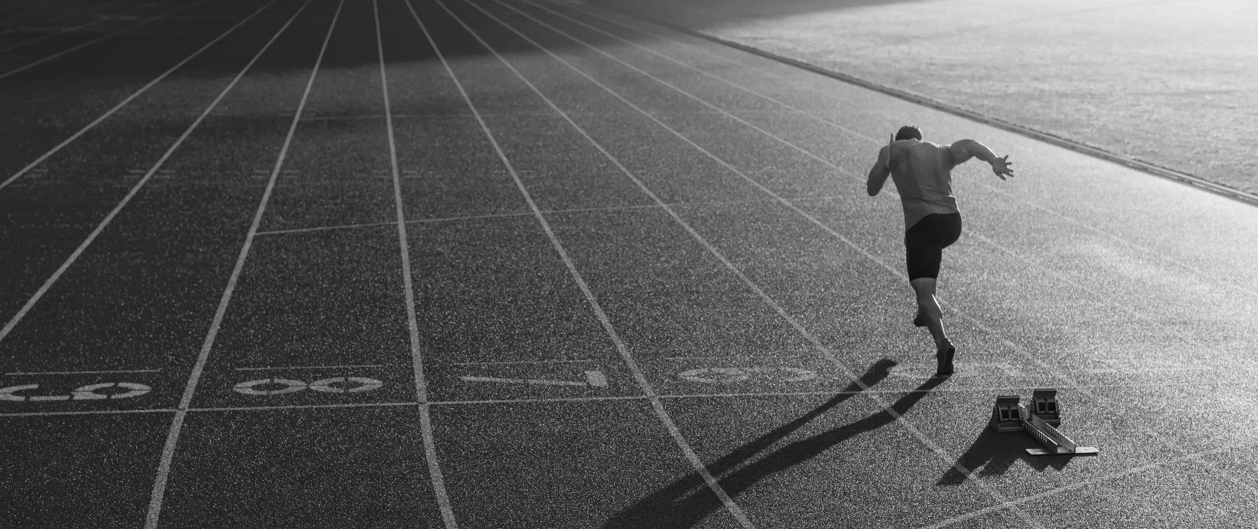 A runner in athletic gear on a running track.