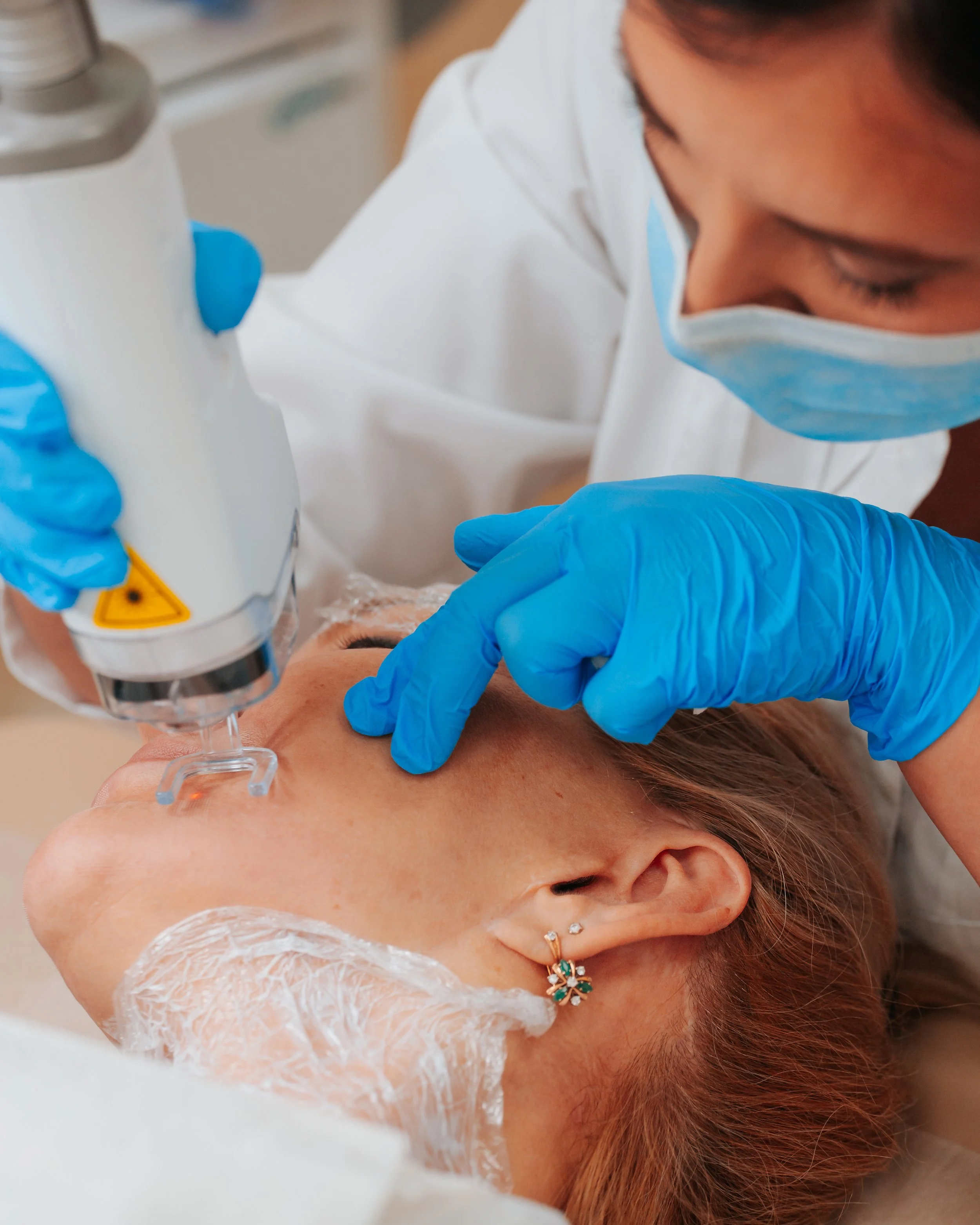 Woman receiving fractional laser treatment on the face by a female dermatologist