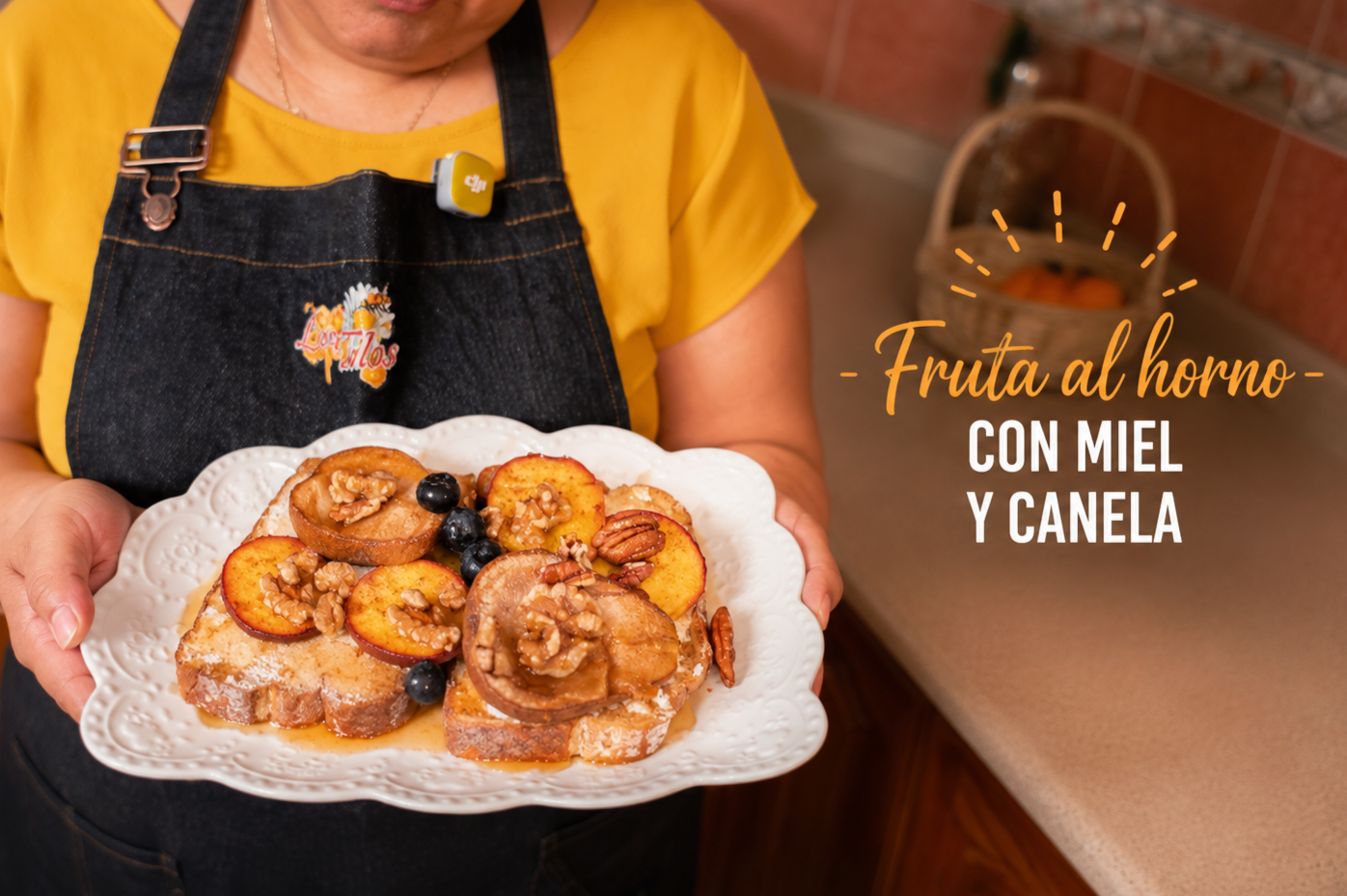 Persona sosteniendo un plato con fruta al horno, miel y canela, en una cocina.