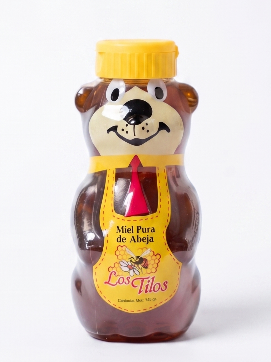Frasco de miel en forma de oso con tapa amarilla, etiqueta que dice 'Miel Pura de Abeja' y un dibujo de una abeja y panal.