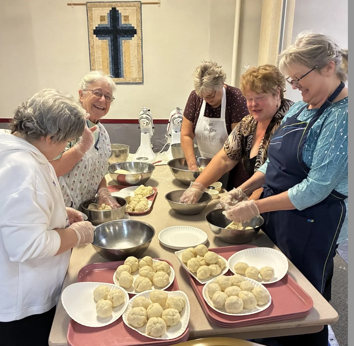 Women rolling Norwegian lefse balls of dough.