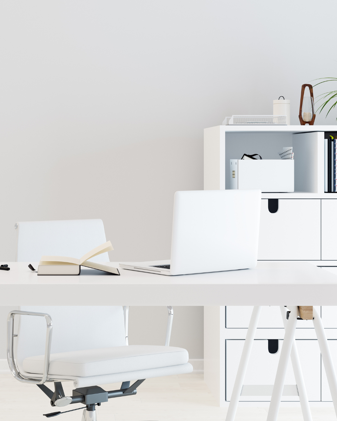Minimalist home office with white desk, an open book, a closed laptop, a white office chair, and white shelf with folders, books, and decorative items.