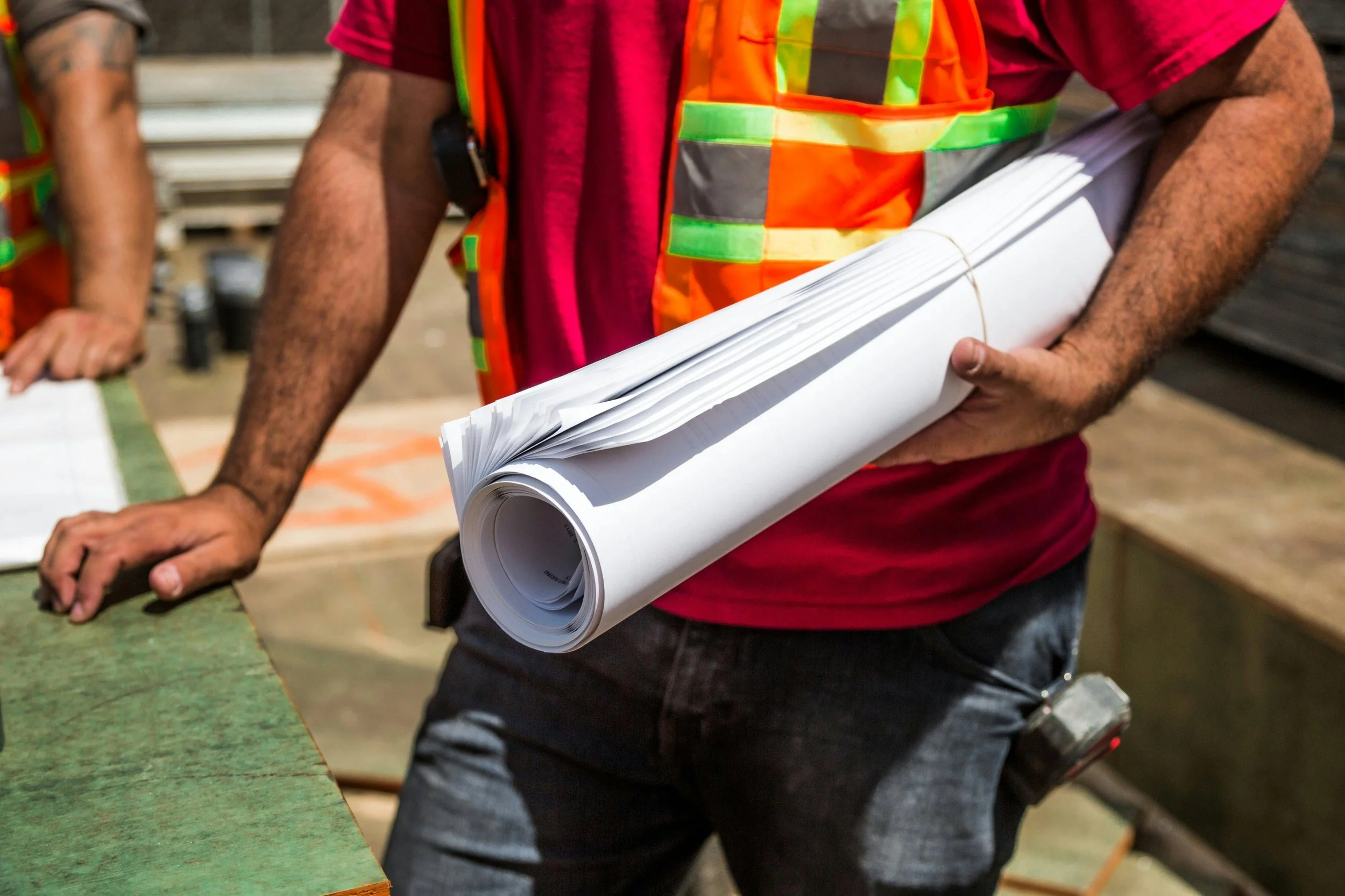 A construction worker holding blueprints. We offer affordable residential design services in Idaho, including cities such as Boise, Meridian, Eagle, Kuna, McCall, Cascade, Caldwell, Melba, Middleton, Star, Horseshoe Bend, Emmett, and Marsing.
