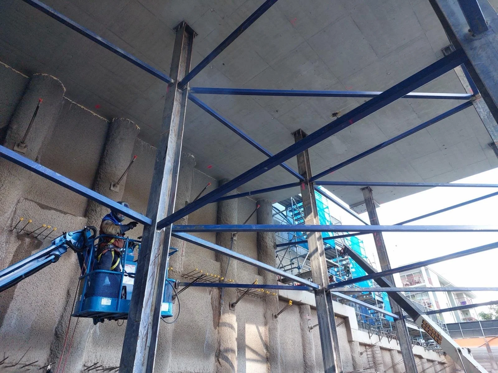 Construction worker with safety gear working on scaffolding at a building site