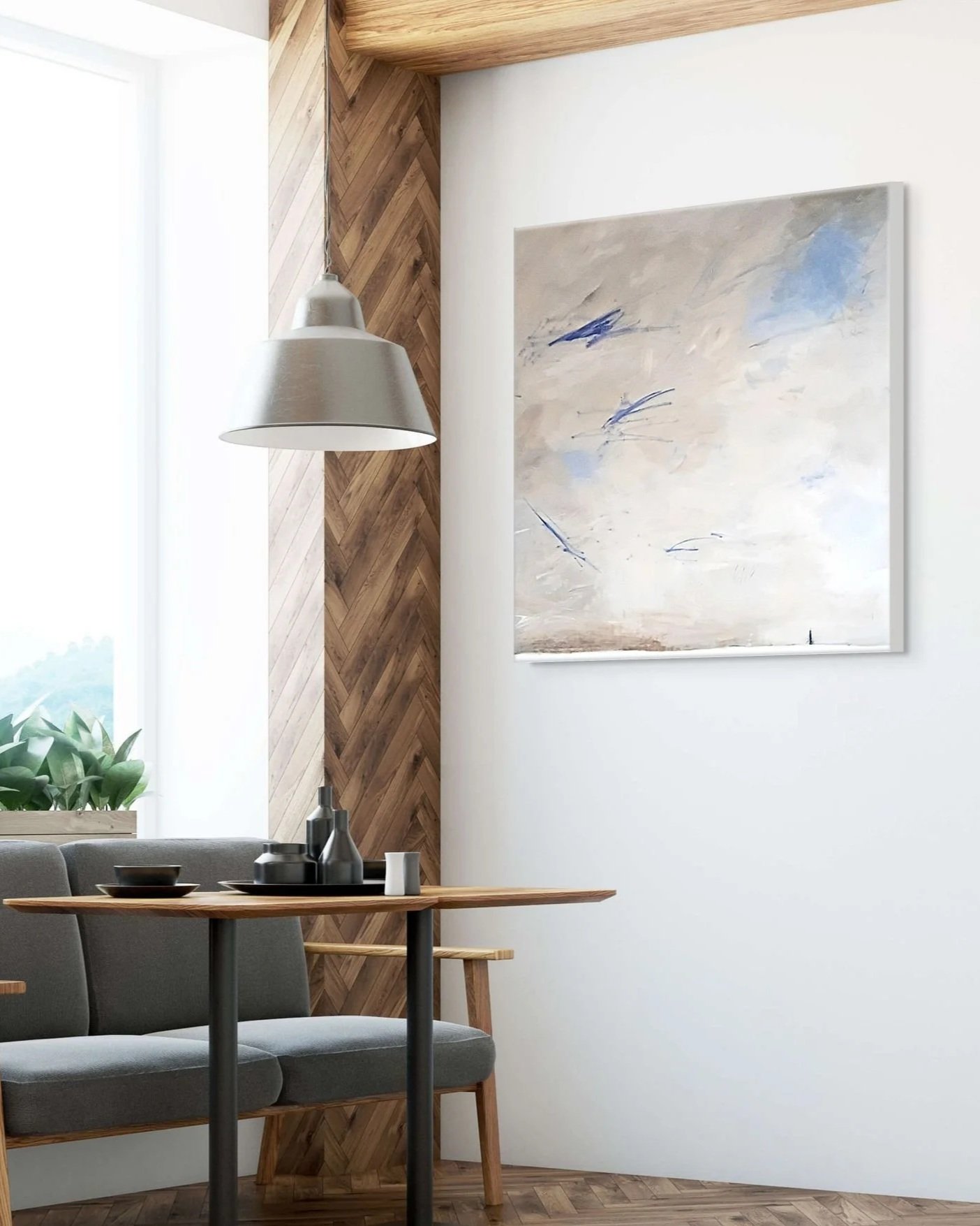 Interior of a modern dining room with a wooden table, gray upholstered chairs, a wall-mounted abstract painting, a pendant light, a window with a view of greenery, and a wooden accent wall.