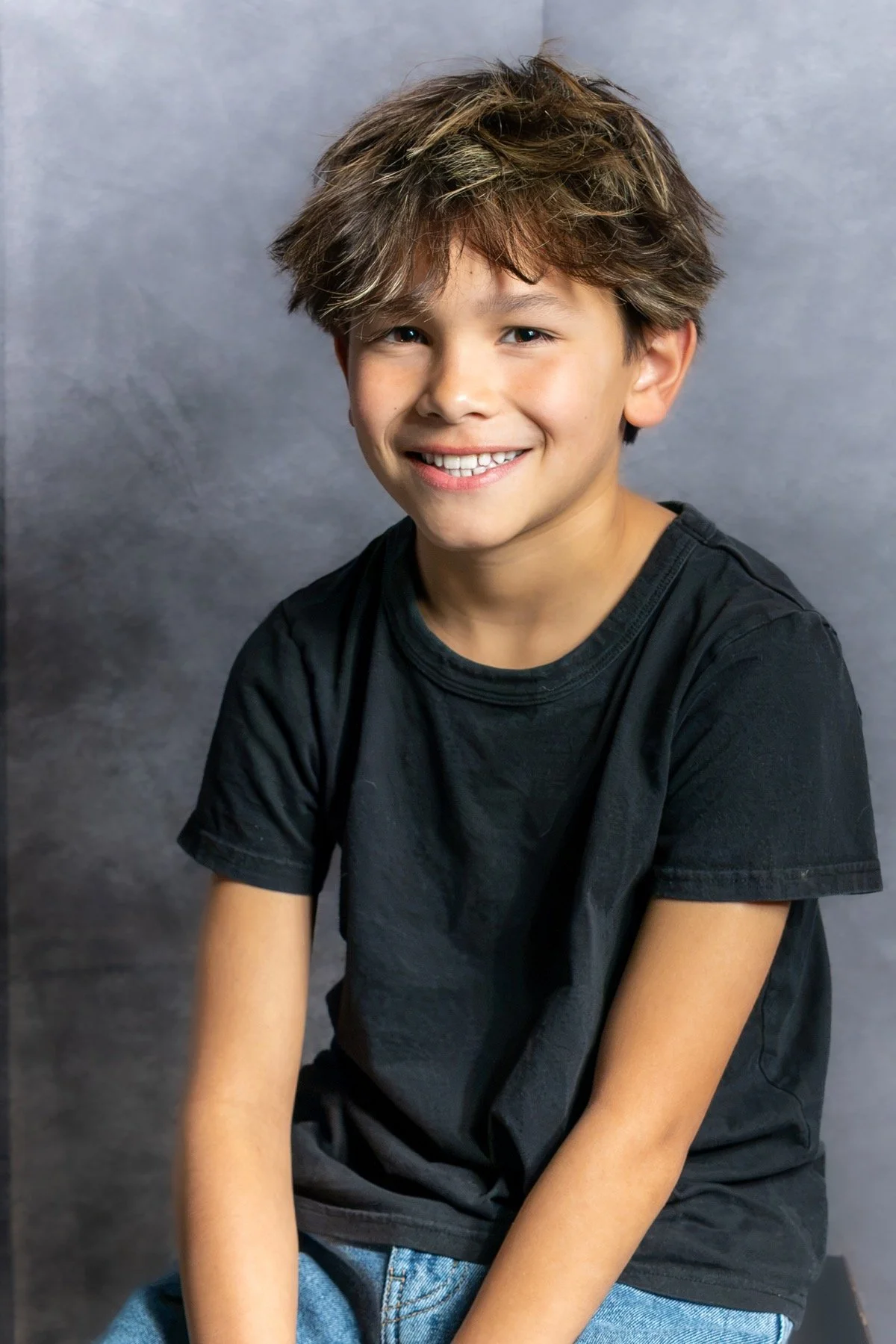 Young athlete seated for a studio portrait against a neutral backdrop