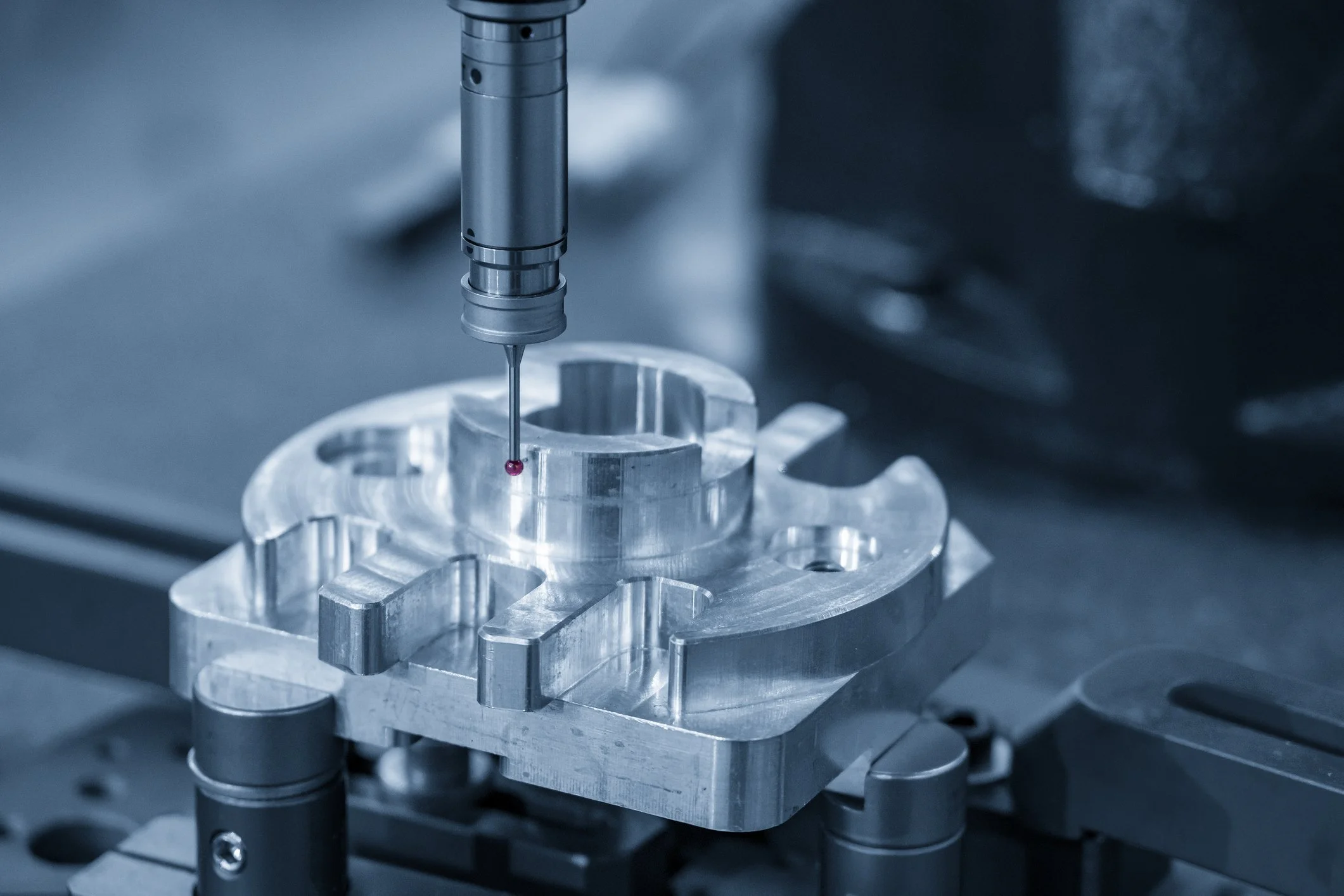 Close-up of a precision machine process involving a metallic component and a drill or needle, with a focus on detailed metalwork and machinery.