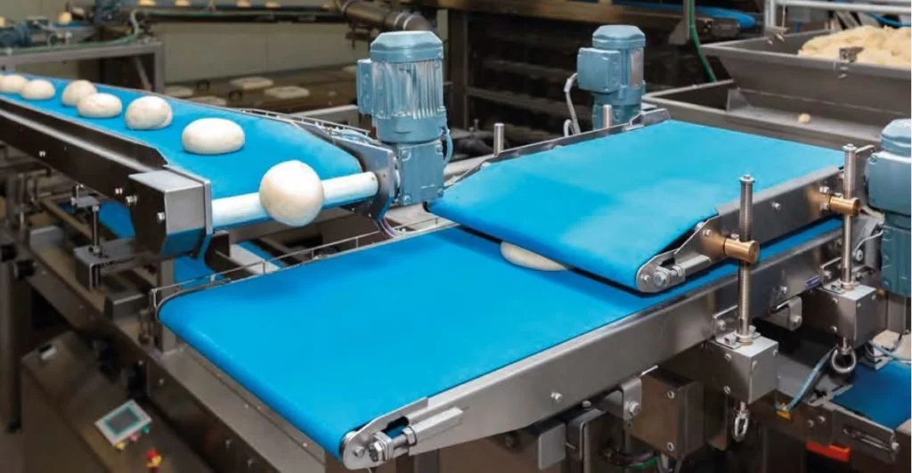 Maquinaria en una línea de producción para empaquetar y mover bolas de masa en una fábrica de alimentos.