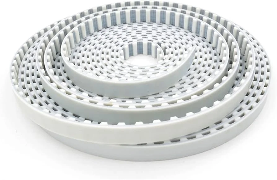 Reloj de cuerda en espiral gris y blanco, emplazado en una superficie blanca.