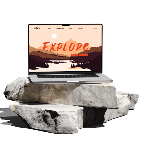 Laptop on large rocks with a scenic mountain and lake background on the screen displaying the word 'Explore' in bold letters.