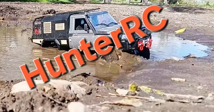 A remote-controlled toy truck inside a muddy water-filled area, with large orange text saying "HunterRC" overlaid on the image.