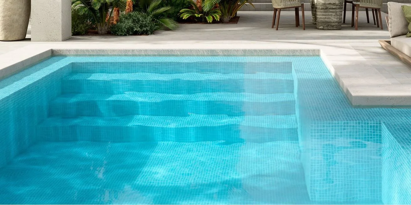 A swimming pool with blue water and tiled steps, surrounded by patio furniture and plants.
