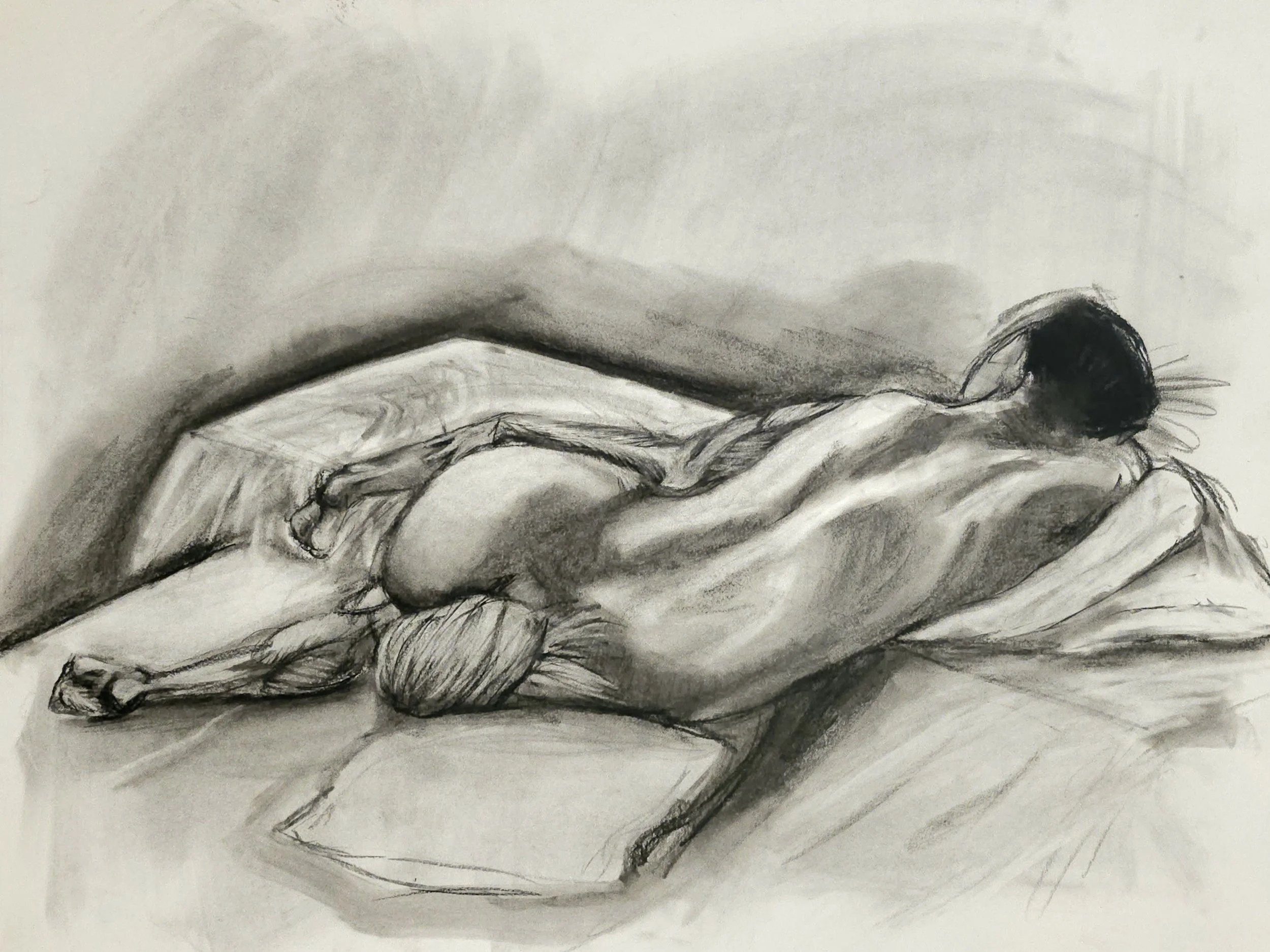 A black and white sketch of a woman lying on her side on a bed, her head resting on her bent arm, muscular anatomy placement of leg.