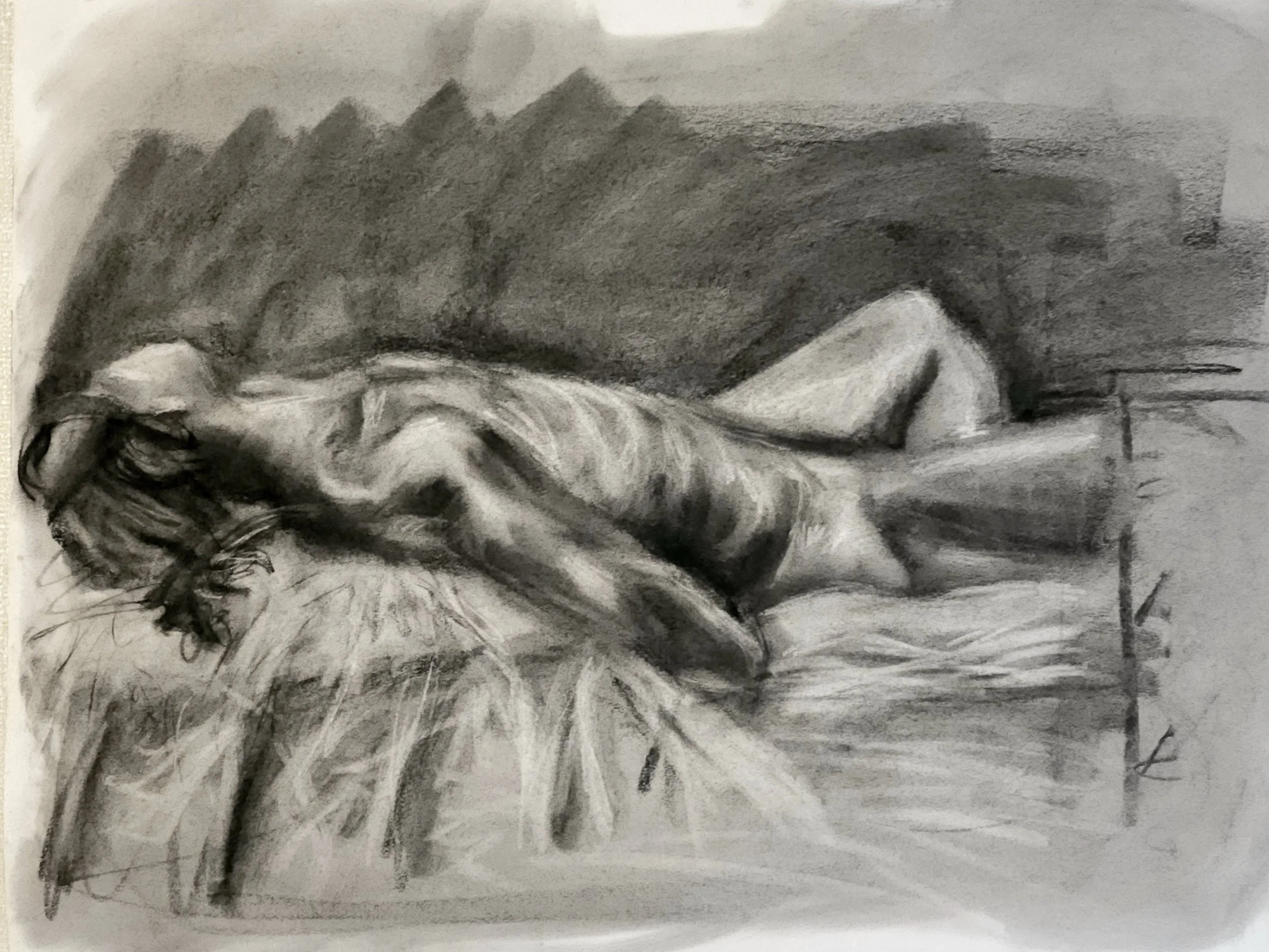 A black and white charcoal figure drawing of a person on textile material.