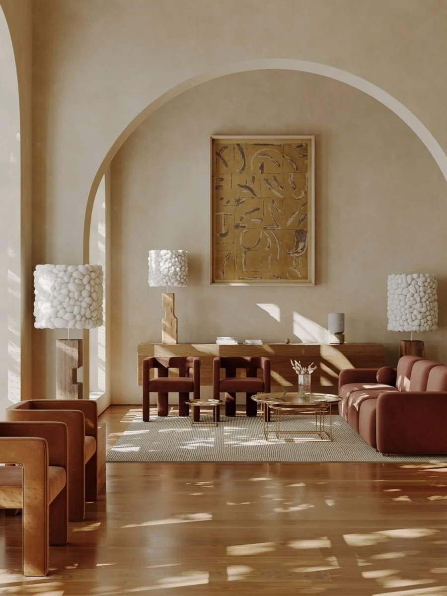 A cozy living room with a leather sofa, wooden chairs, modern lamps with white textured shades, a wooden sideboard, and abstract wall art, with sunlight creating shadows on the wooden floor.