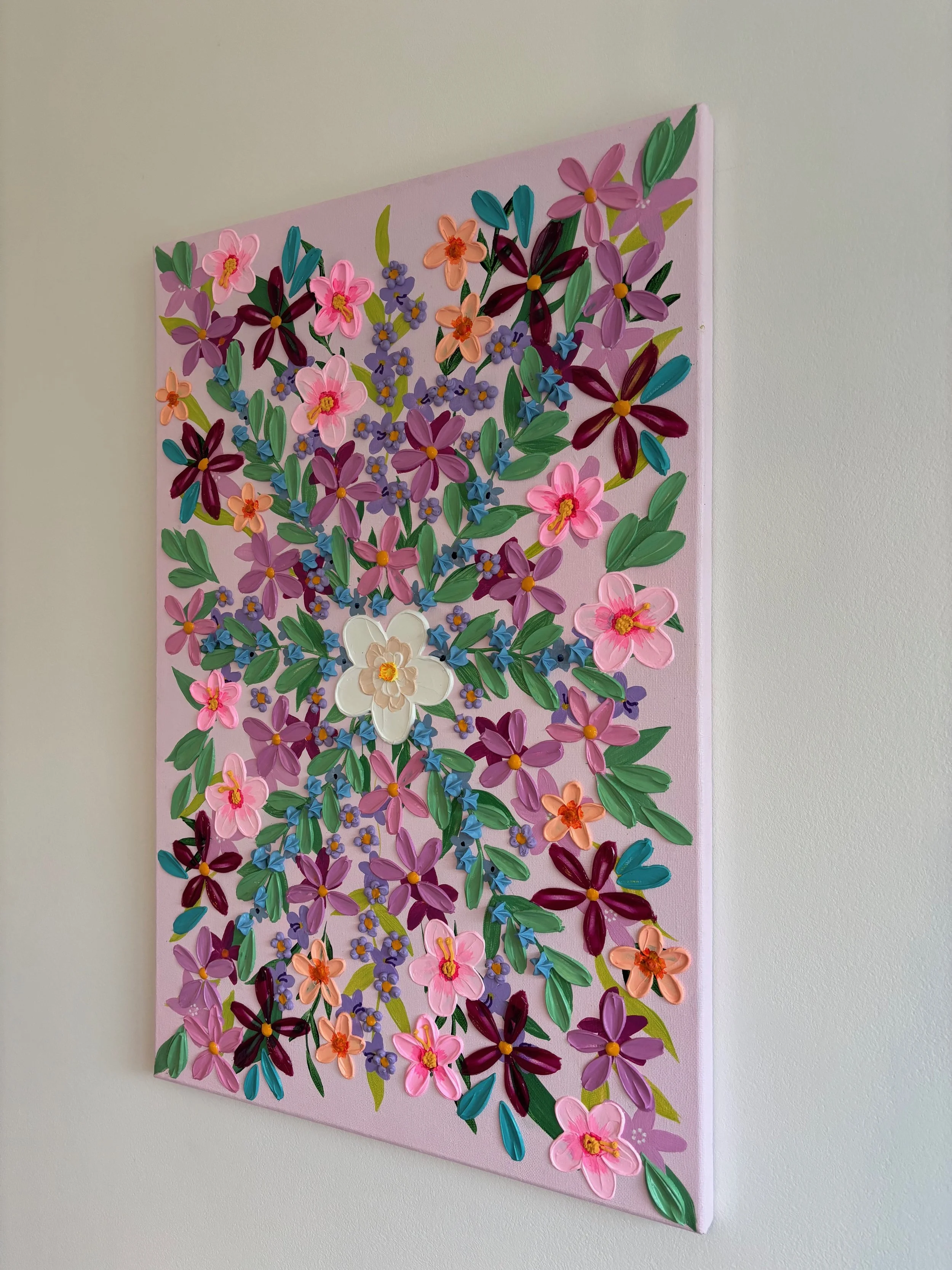 Heavily textured floral painting with colourful flowers on a soft pink background