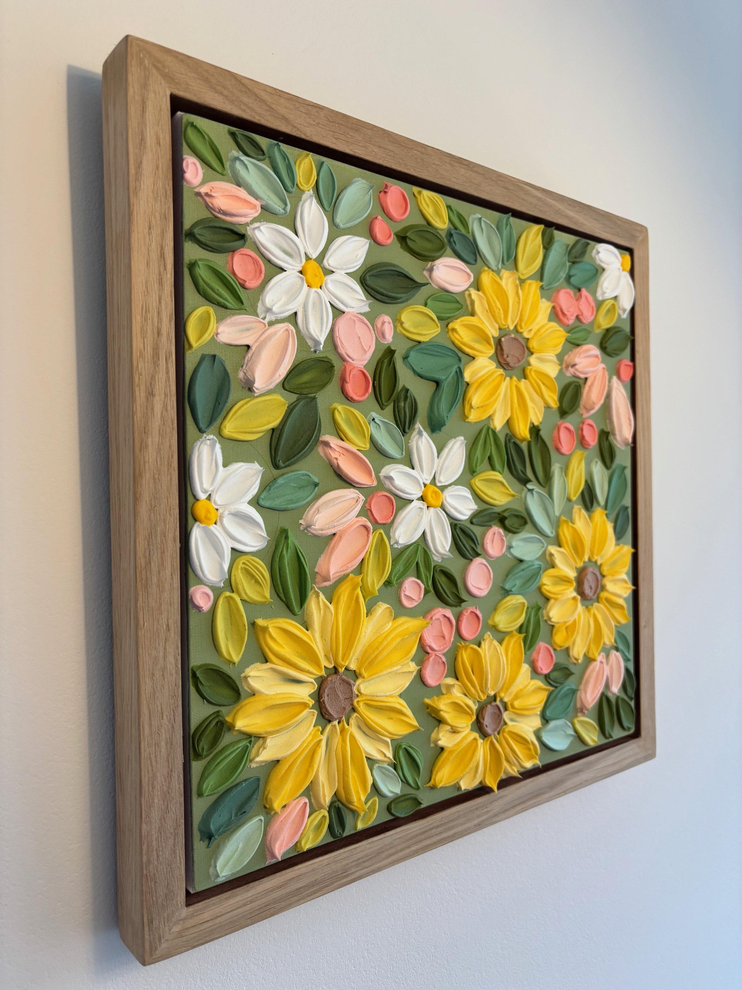 Textured floral wall art featuring large yellow sunflowers on olive green background