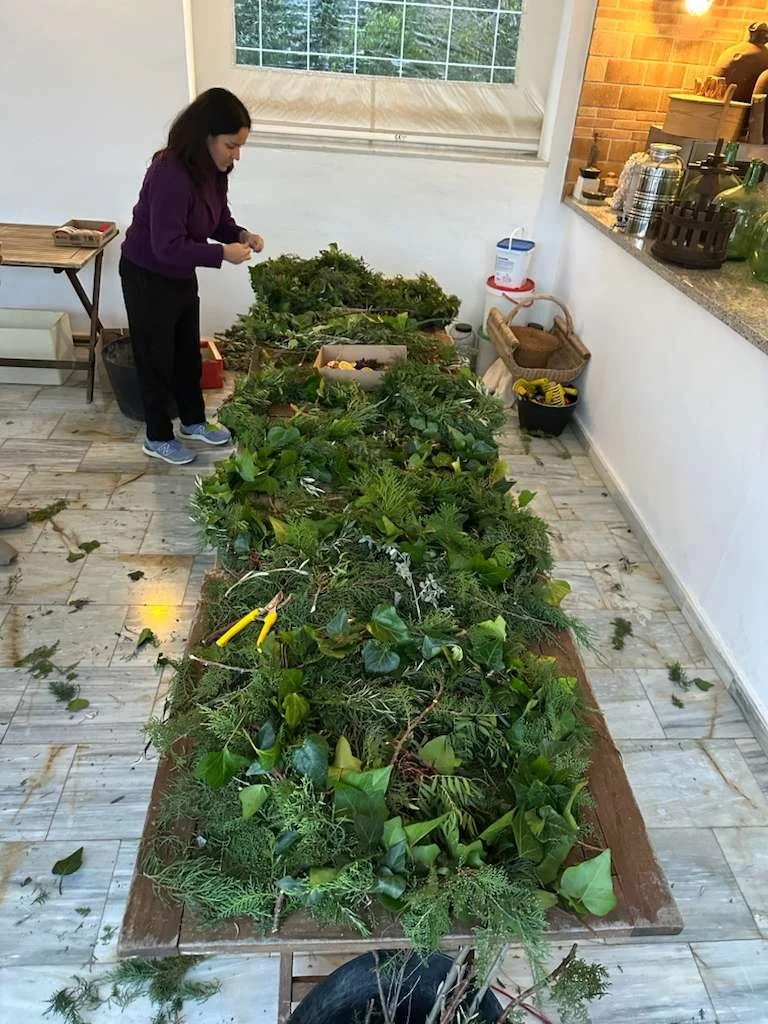 Festive wreath-making workshop with greenery, pine cones and dried orange slices.