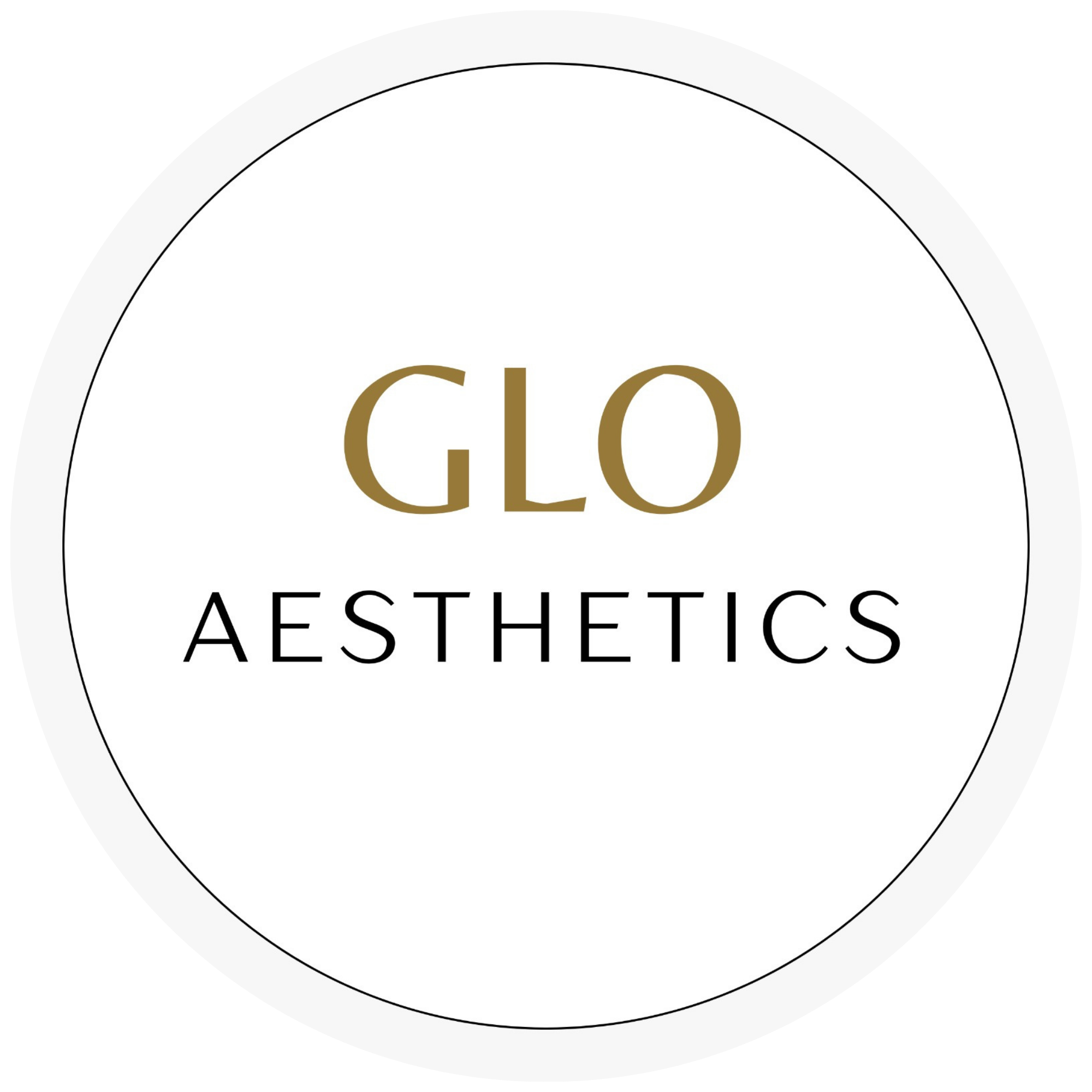 Close-up of a circular logo with the words 'GLO AESTHETICS' in gold and black text on a white background, featuring black and gray borders.