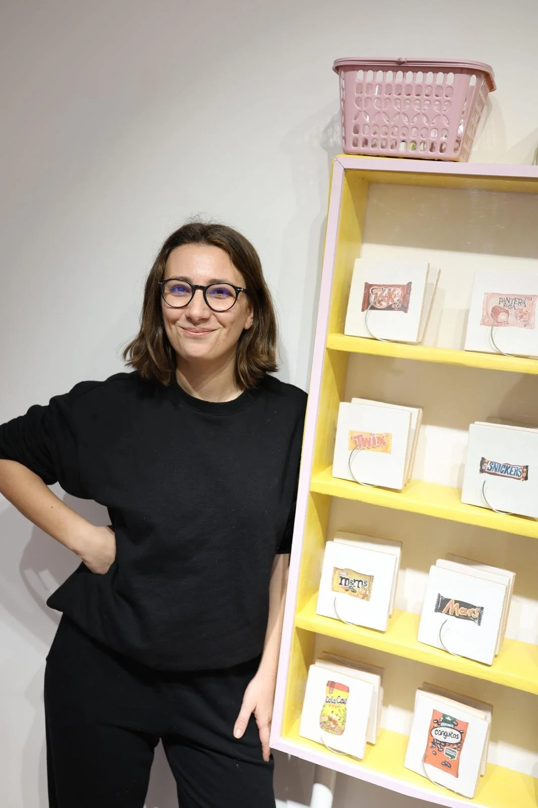 Lucía Palanca, creadora de Bylajuana, junto a la estantería amarilla de la exposición Snack Attack