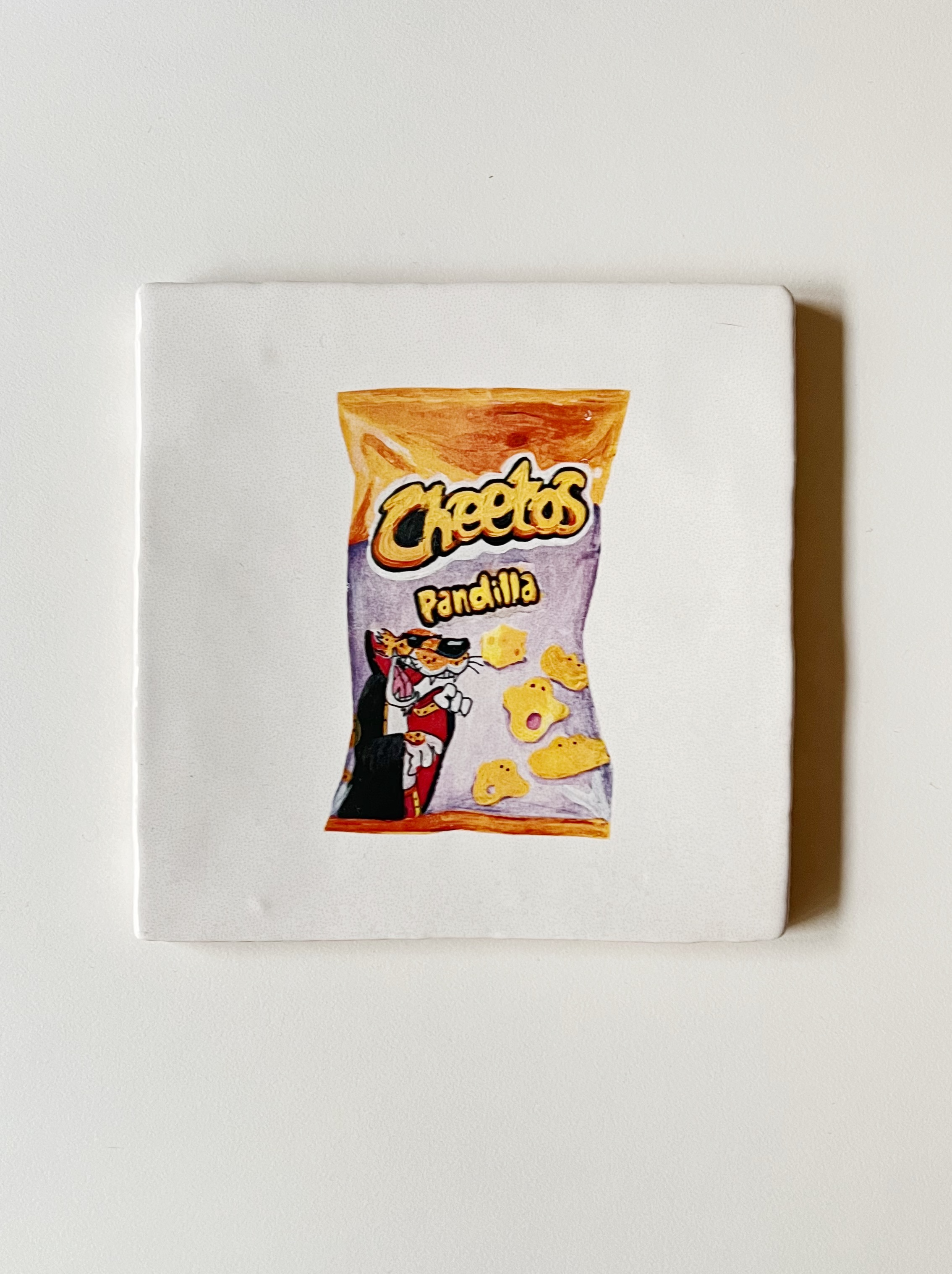 Ilustración sobre azulejo de una bolsa de Cheetos creado Bylajuana