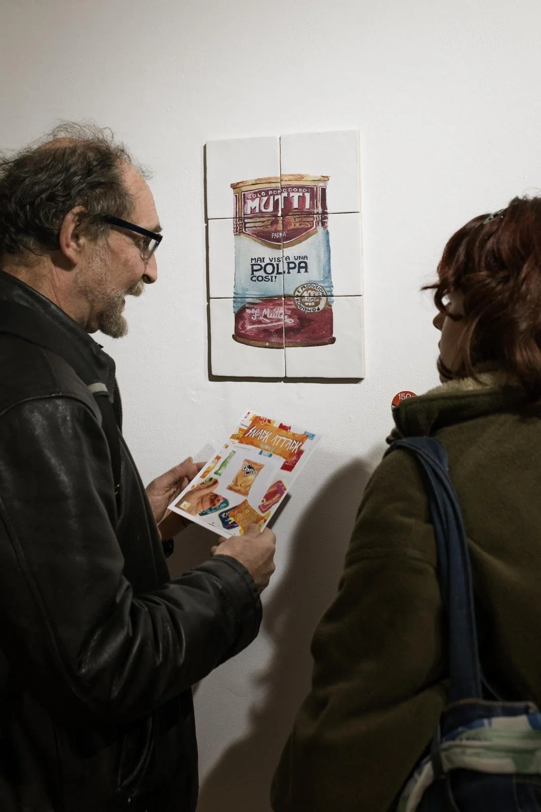 Visitantes de la exposición Picnic de Bylajuana en la Snack Attack en Cáceres, viendo un mosaico de azulejos