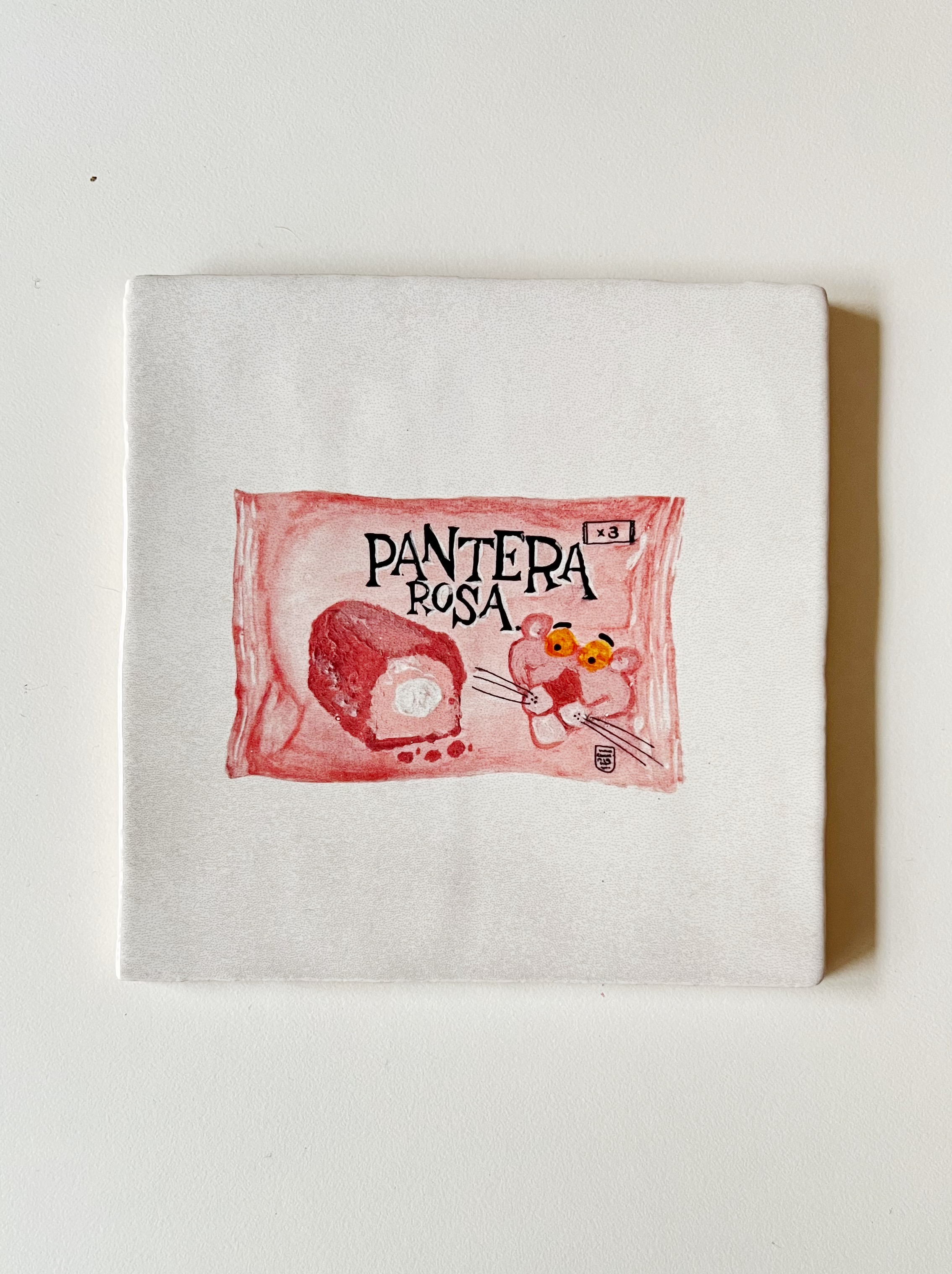 Ilustración sobre azulejo de un bizcocho Pantera Rosa creada por Bylajuana