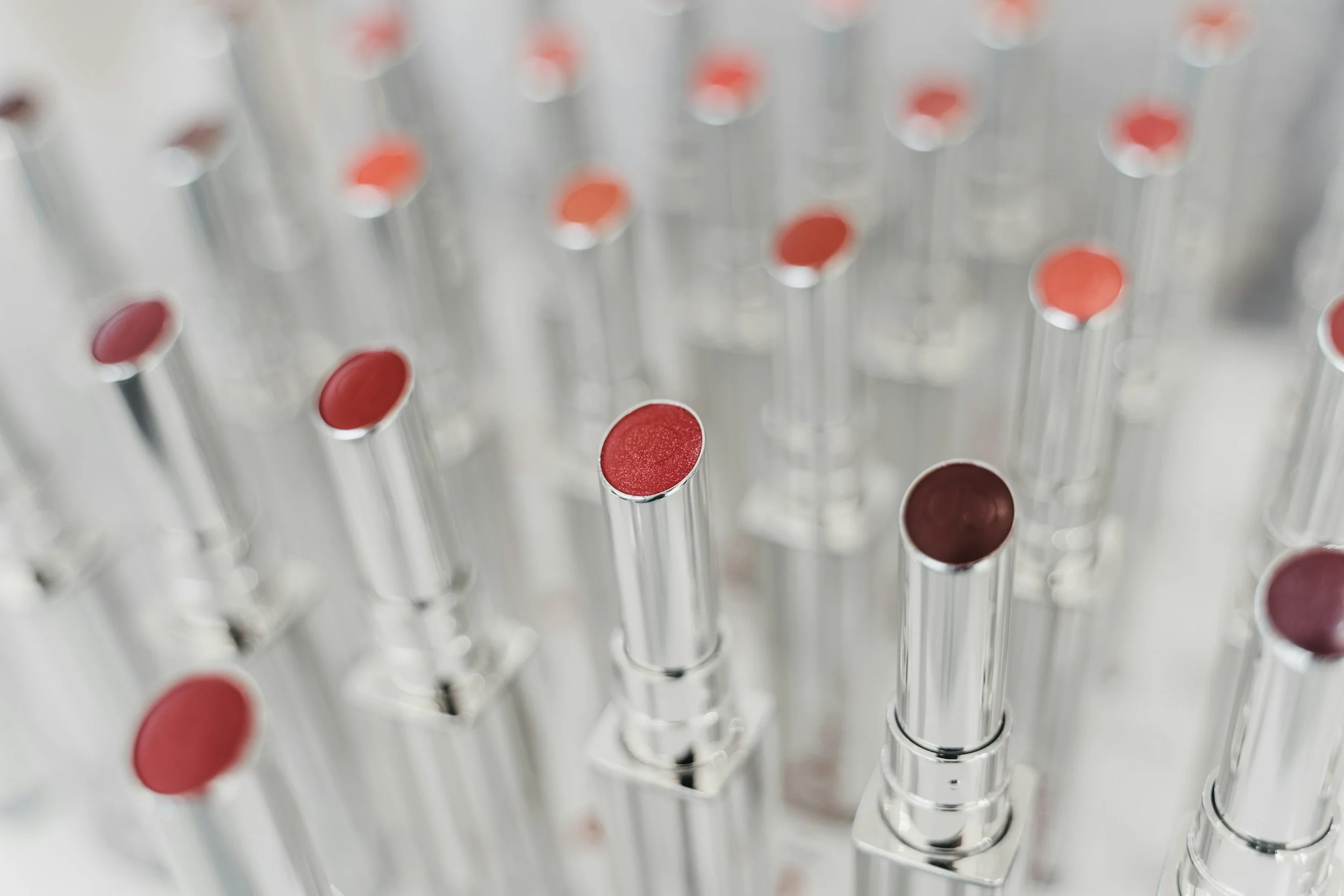 Close-up of multiple glass vials with red caps, arranged in a grid, with some in focus and others blurred.